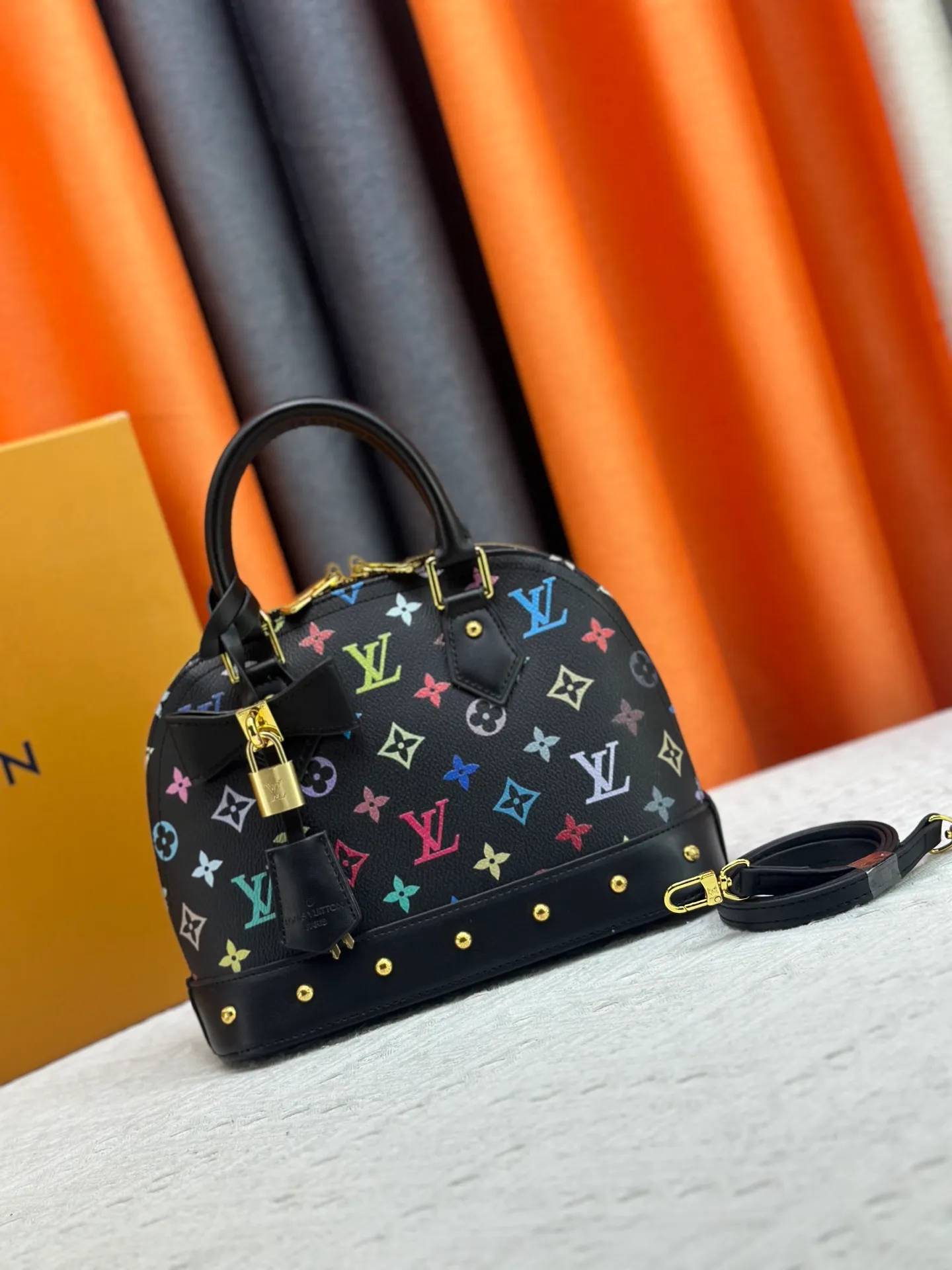 P300 Upgraded original M13078 M53152 This Alma BB handbag exudes the cheerful style of the Louis Vuitton x Murakami collaboration series, cleverly recalling the Art Deco design of the 1930s. Monogram coated canvas renders Murakami's playful tones, while classic calfskin touches the Toron handle, base, detachable shoulder strap and LV x TM key holder. 17.5 x 11.5 x 23.5 cm (height x width x length)