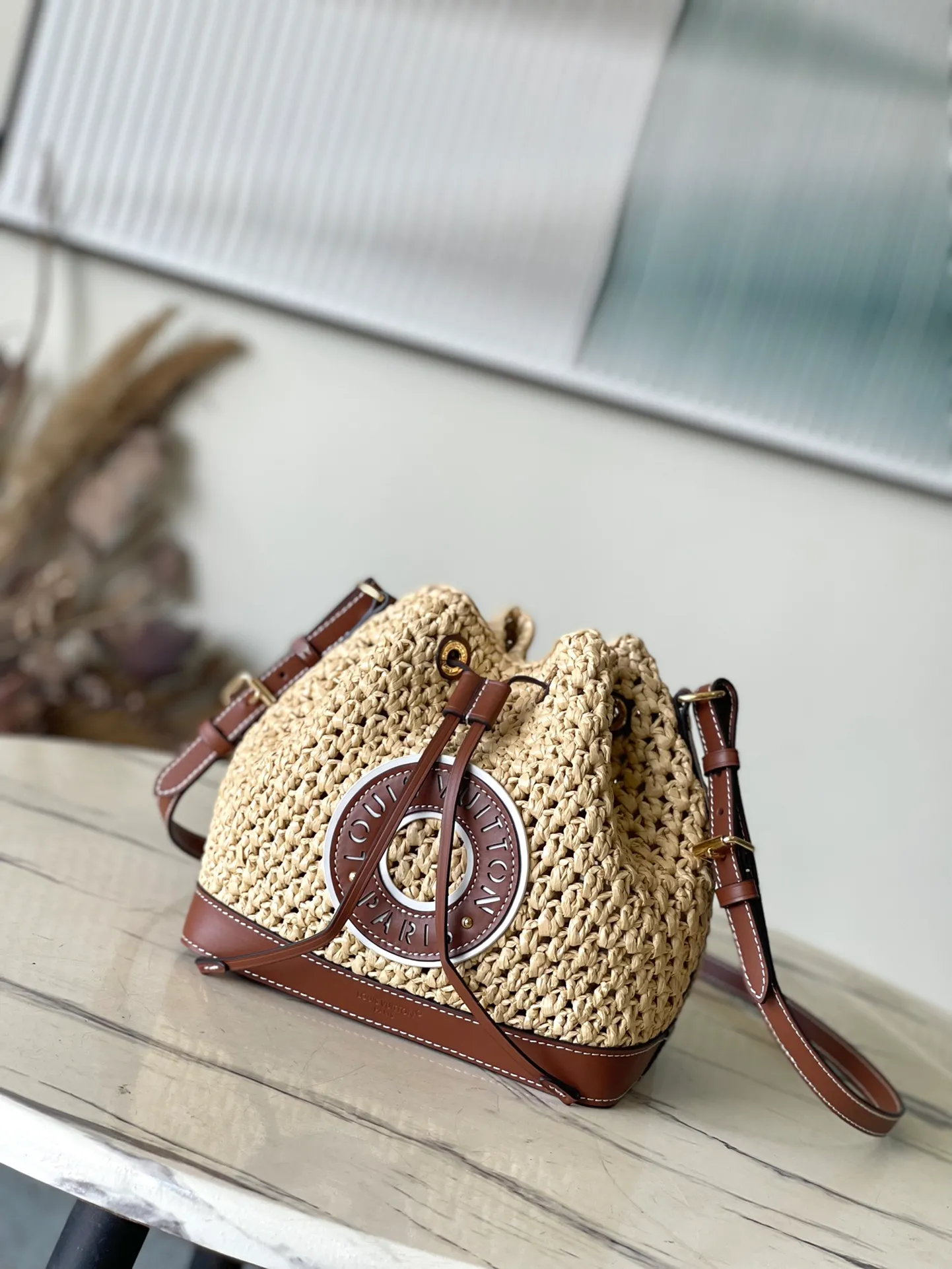 💰1100 Top Original Order M24722 This NoeBB bucket bag is made of raffia crocheted by Madagascar craftsmen. It is decorated with gorgeous leather to highlight the brand's exquisite craftsmanship, achieving a comfortable texture and personalized style. Dimensions: 22 × 24 × 15 cm