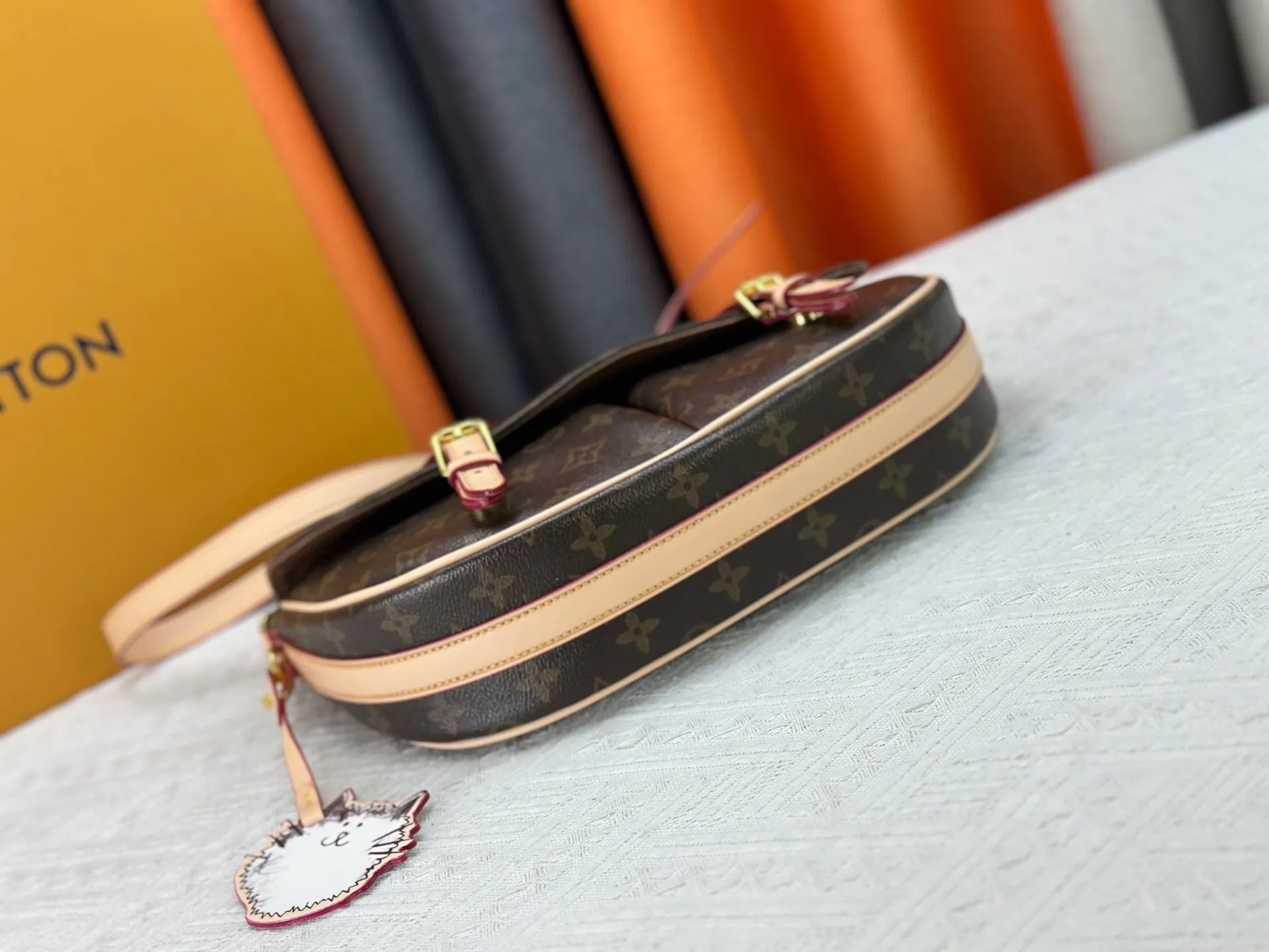 The P300 M15134 Escape handbag makes an eye-catching appearance in the LV Travels With Grace Coddington series. It is a canvas bag with a fun Meowgram pattern and a cat-shaped leather decoration hand-painted by Coddington himself. The flexible design provides a variety of carrying methods and can easily accommodate various daily needs. Dimensions: 21 x 7 x 30 cm