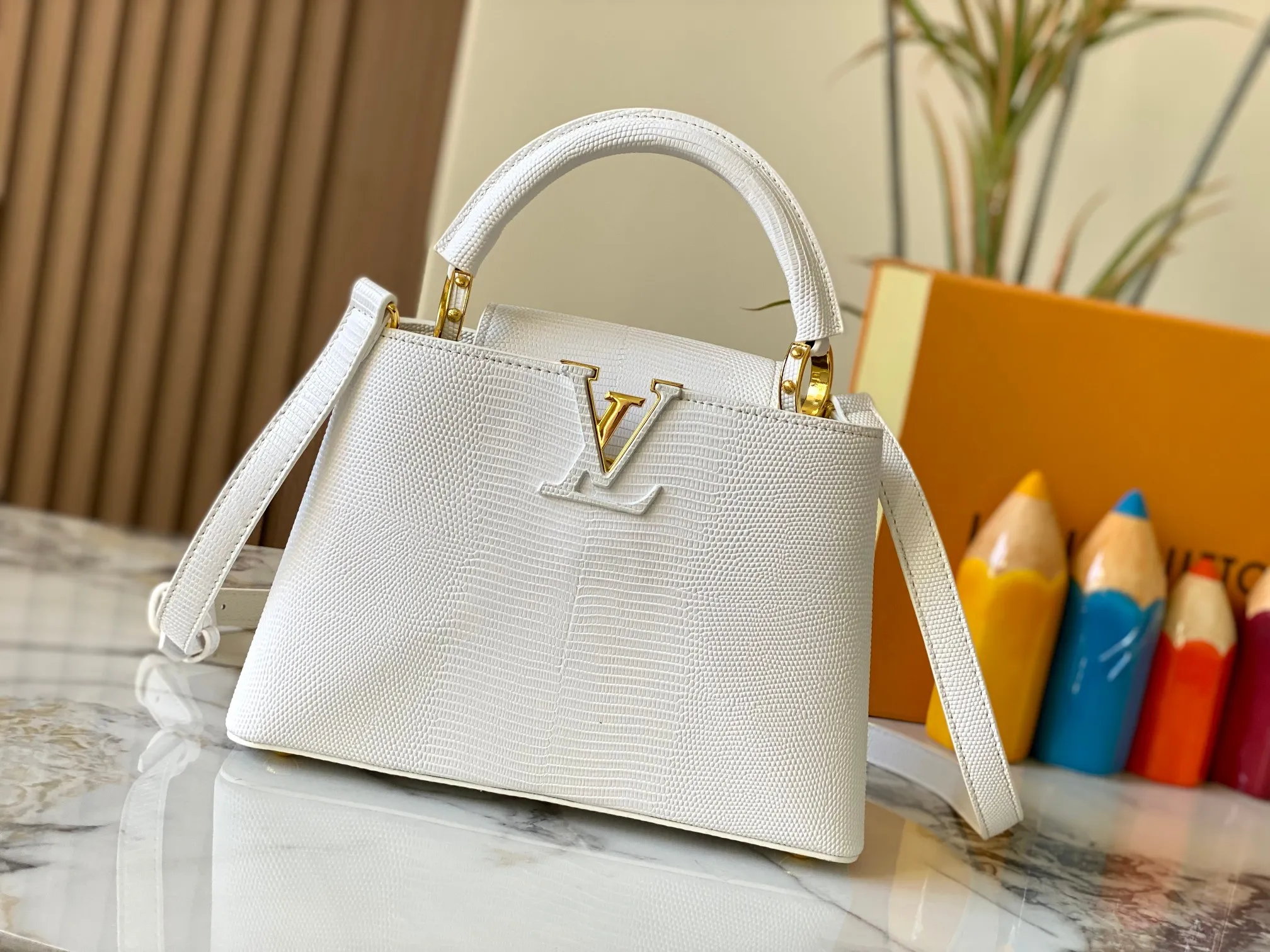 Top original P440 Guangzhou-made M99528 white lizard skin gold buckle CapucinesBB handbag exquisitely combines graceful lizard skin outer layer, delicate sheepskin lining and glossy metal parts. The iconic flip cover makes two styles fashionable. The LV logo is read on the inside and Monogram flowers bloom on the outside. It lights up an eye-catching corner for evening occasions and adds a personalized atmosphere to the wardrobe. Shine gorgeous style in day and night occasions.  Detailed features 27 x 18 x 9 cm (length x height x width)