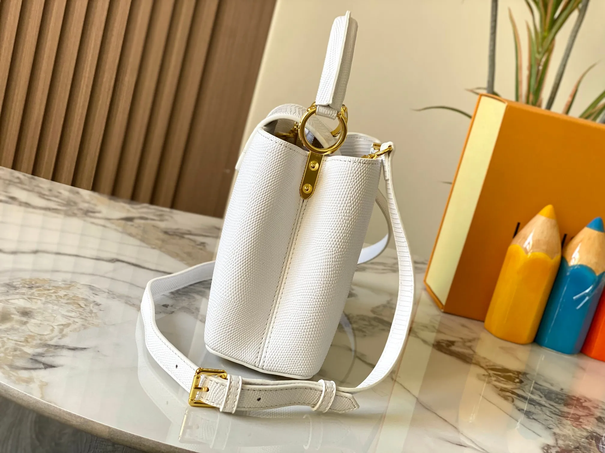Top original P440 Guangzhou-made M99528 white lizard skin gold buckle CapucinesBB handbag exquisitely combines graceful lizard skin outer layer, delicate sheepskin lining and glossy metal parts. The iconic flip cover makes two styles fashionable. The LV logo is read on the inside and Monogram flowers bloom on the outside. It lights up an eye-catching corner for evening occasions and adds a personalized atmosphere to the wardrobe. Shine gorgeous style in day and night occasions.  Detailed features 27 x 18 x 9 cm (length x height x width)