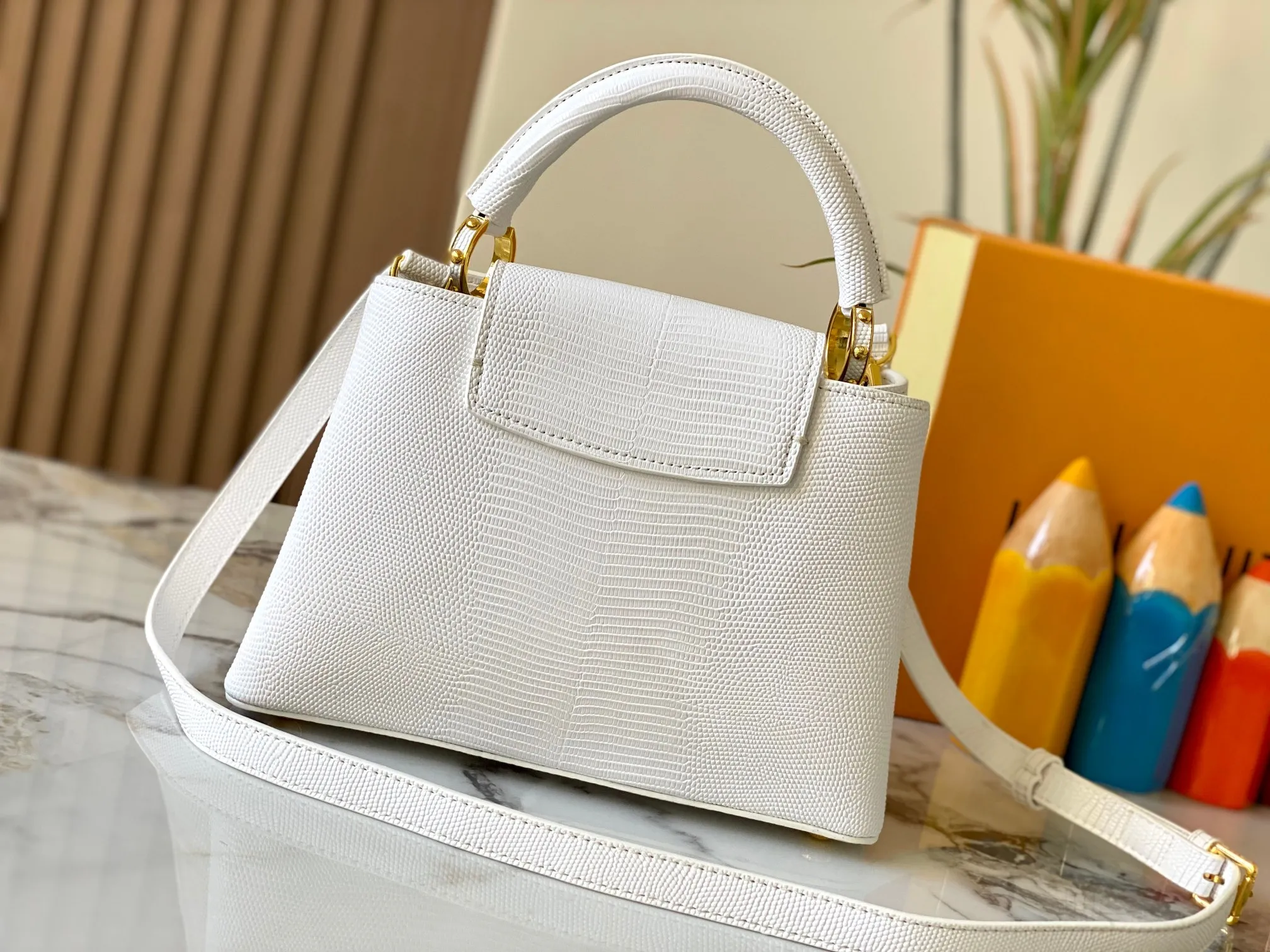 Top original P440 Guangzhou-made M99528 white lizard skin gold buckle CapucinesBB handbag exquisitely combines graceful lizard skin outer layer, delicate sheepskin lining and glossy metal parts. The iconic flip cover makes two styles fashionable. The LV logo is read on the inside and Monogram flowers bloom on the outside. It lights up an eye-catching corner for evening occasions and adds a personalized atmosphere to the wardrobe. Shine gorgeous style in day and night occasions.  Detailed features 27 x 18 x 9 cm (length x height x width)