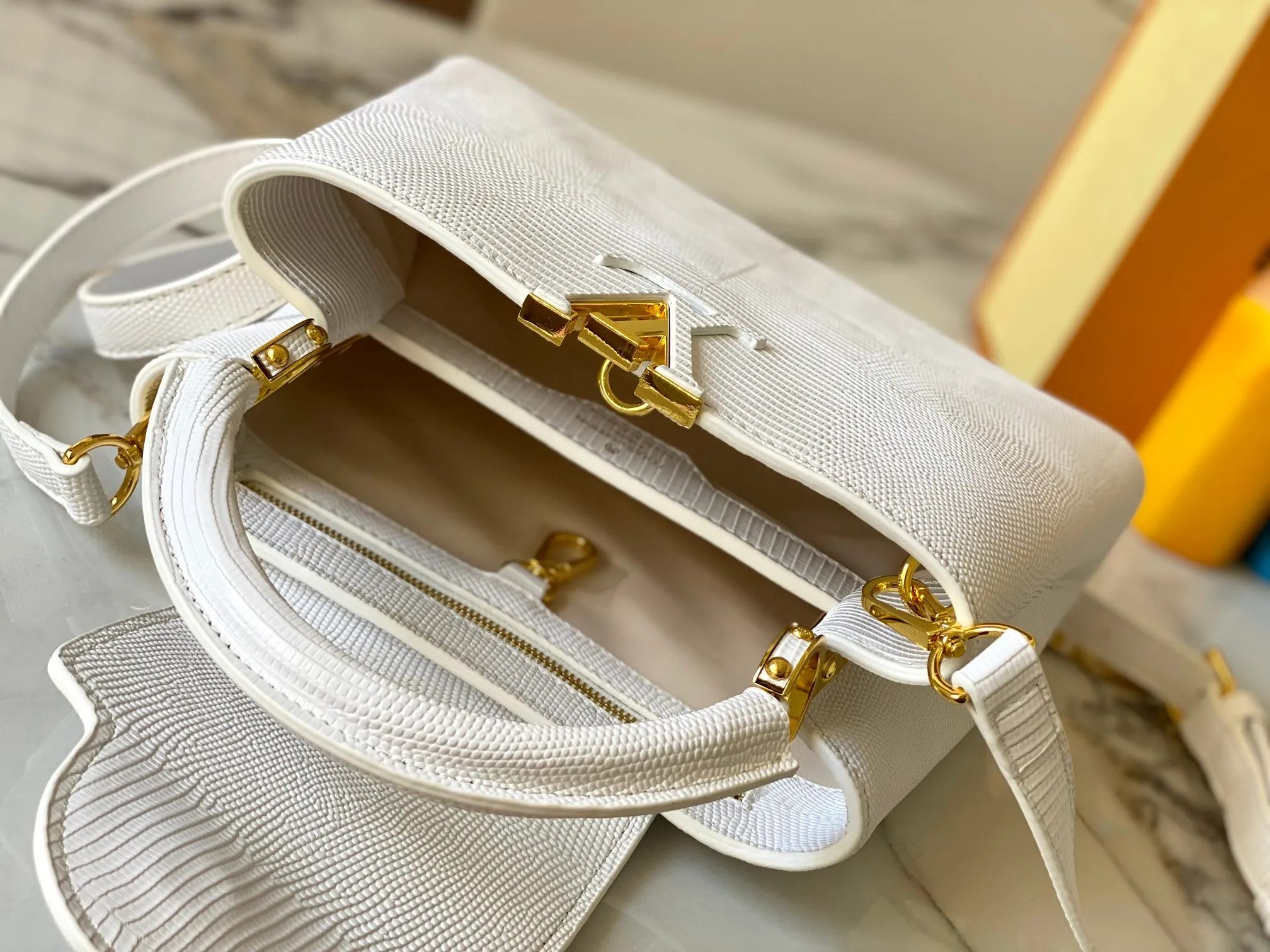 Top original P440 Guangzhou-made M99528 white lizard skin gold buckle CapucinesBB handbag exquisitely combines graceful lizard skin outer layer, delicate sheepskin lining and glossy metal parts. The iconic flip cover makes two styles fashionable. The LV logo is read on the inside and Monogram flowers bloom on the outside. It lights up an eye-catching corner for evening occasions and adds a personalized atmosphere to the wardrobe. Shine gorgeous style in day and night occasions.  Detailed features 27 x 18 x 9 cm (length x height x width)