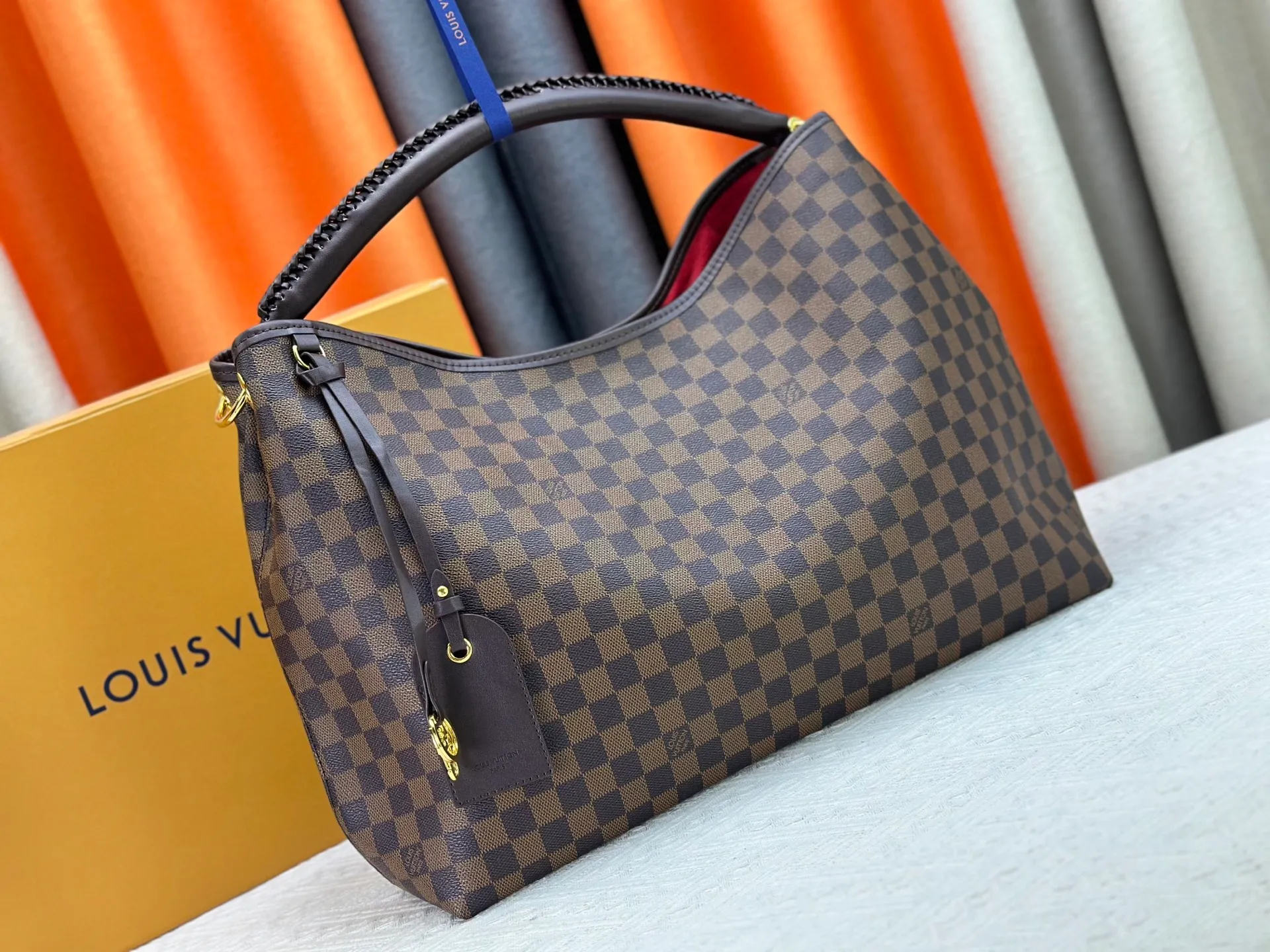 P300 upgrades the original M25877 Again bag, a new interpretation of the iconic Artsy design first launched in 2010, now more flexible, more iconic and more refined. Rooted in LV’s DNA, this bag pays homage to Louis Vuitton’s craftsmanship with its classic Monogram canvas base, hand-woven handles and customizable name tag. It's spacious enough to hold a laptop and opens to reveal multiple pockets. Gold hooks can be used to hang playful accessories! ! Size:50x30x15.5CM