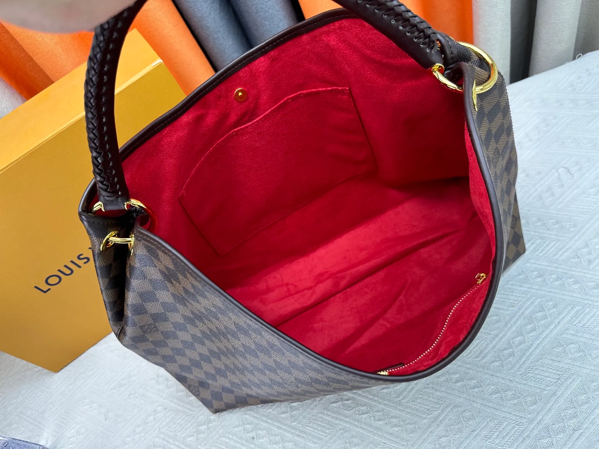 P300 upgrades the original M25877 Again bag, a new interpretation of the iconic Artsy design first launched in 2010, now more flexible, more iconic and more refined. Rooted in LV’s DNA, this bag pays homage to Louis Vuitton’s craftsmanship with its classic Monogram canvas base, hand-woven handles and customizable name tag. It's spacious enough to hold a laptop and opens to reveal multiple pockets. Gold hooks can be used to hang playful accessories! ! Size:50x30x15.5CM
