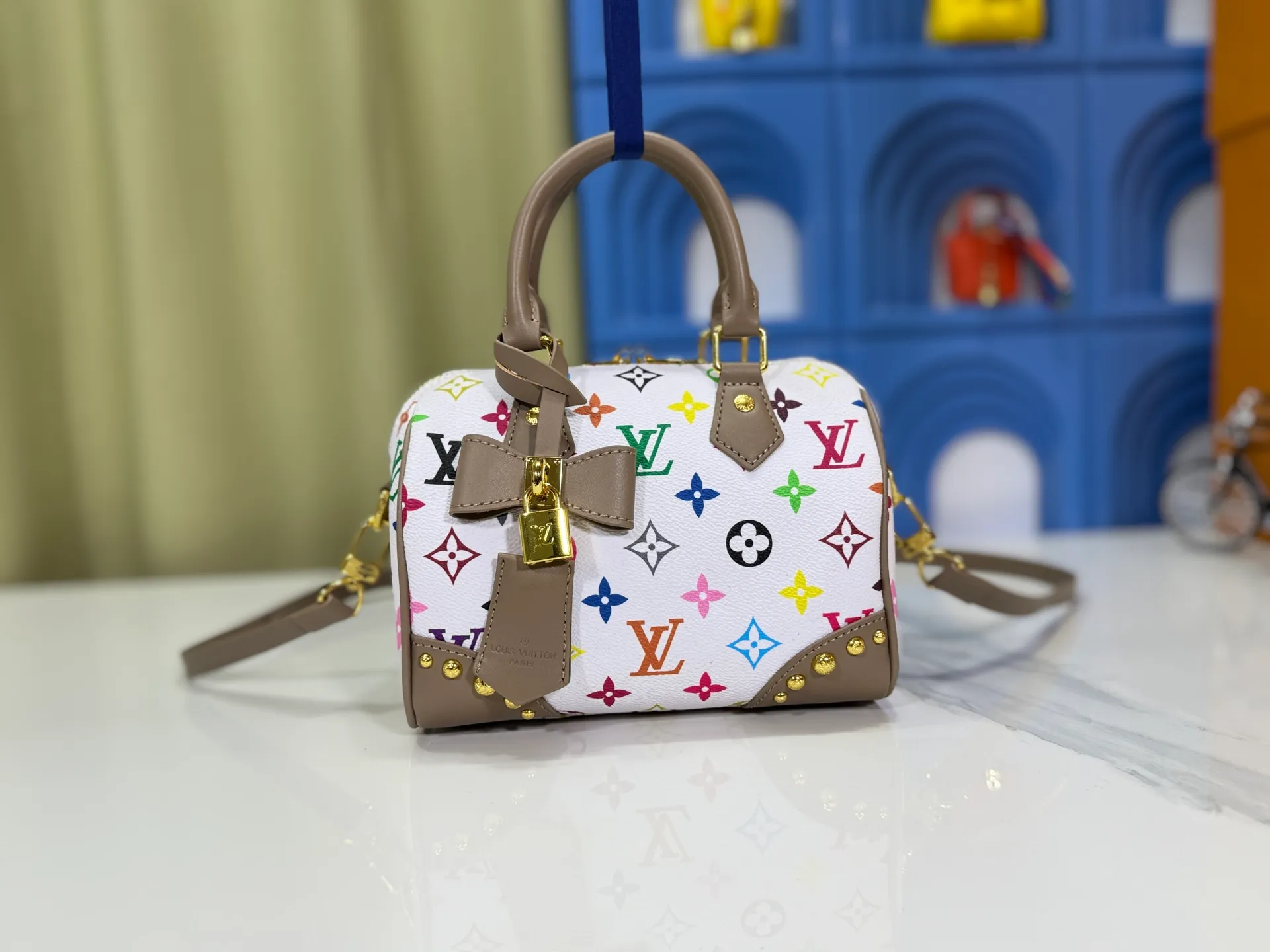 P280 upgraded original M58953 M46234 M46222 Speedy Bandoulière 20 handbag is made of soft coated canvas, and the full-length Monogram pattern is traced in colorful rainbow tones, highlighting the smart style of the Louis Vuitton x Murakami reissue series. The Toron handle and detachable shoulder strap are constructed of cow leather, the metal corners recall classic luggage elements, and the bow-shaped key bag and padlock add brand touches. Dimensions: 20.5 x 13.5 x 12.0 cm (length x height x width)