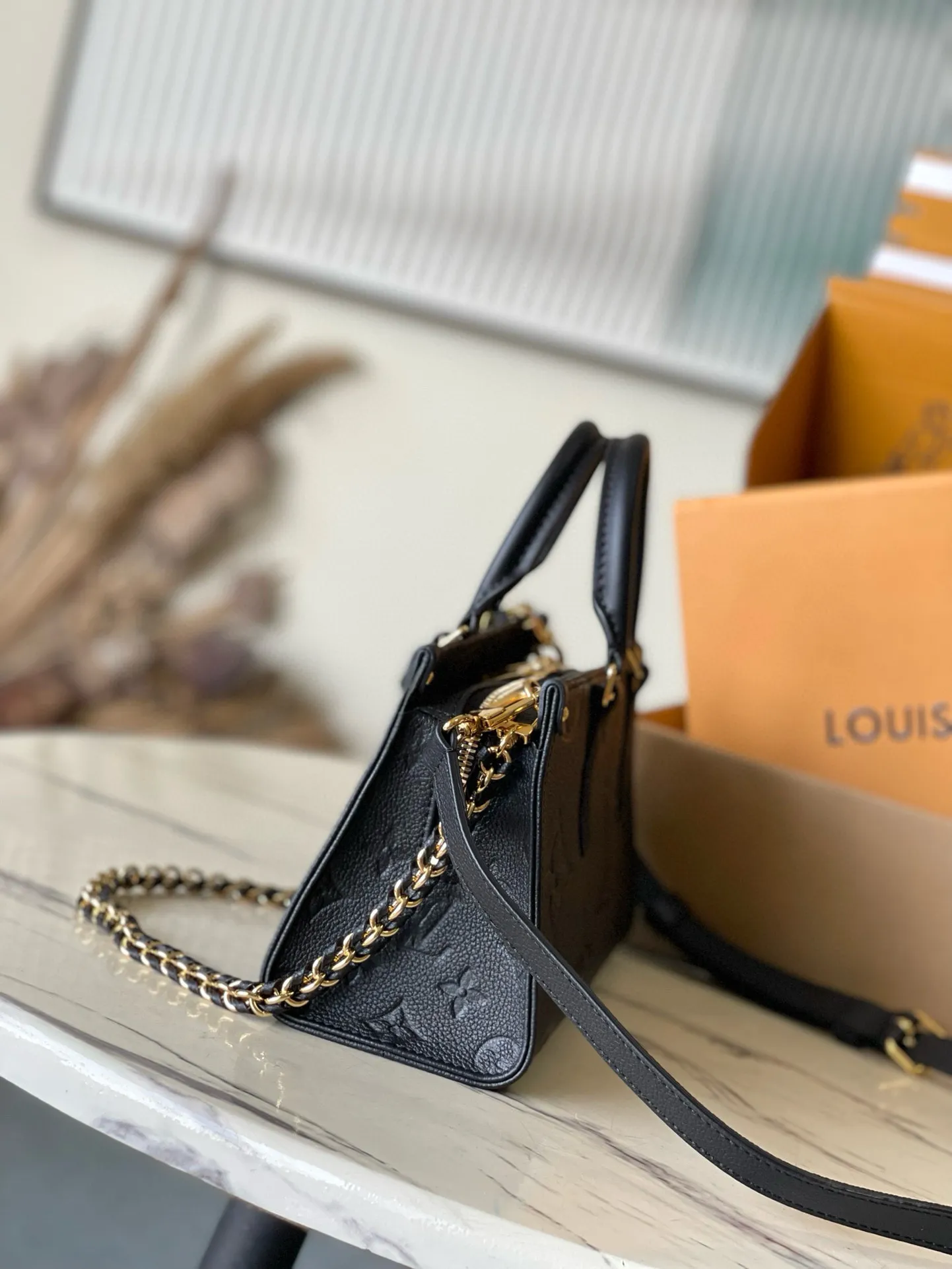 💰1100 (top layer leather) top original order M23640 black This small OnTheGo handbag is made of Monogram Empreinte leather embossed with Giant Monogram pattern, highlighting the soft and slender silhouette. The compact interior keeps your daily essentials organized, while the articulated top handle and detachable leather and woven chain shoulder strap allow for a variety of carrying options. Dimensions: 25 × 13 × 10 cm