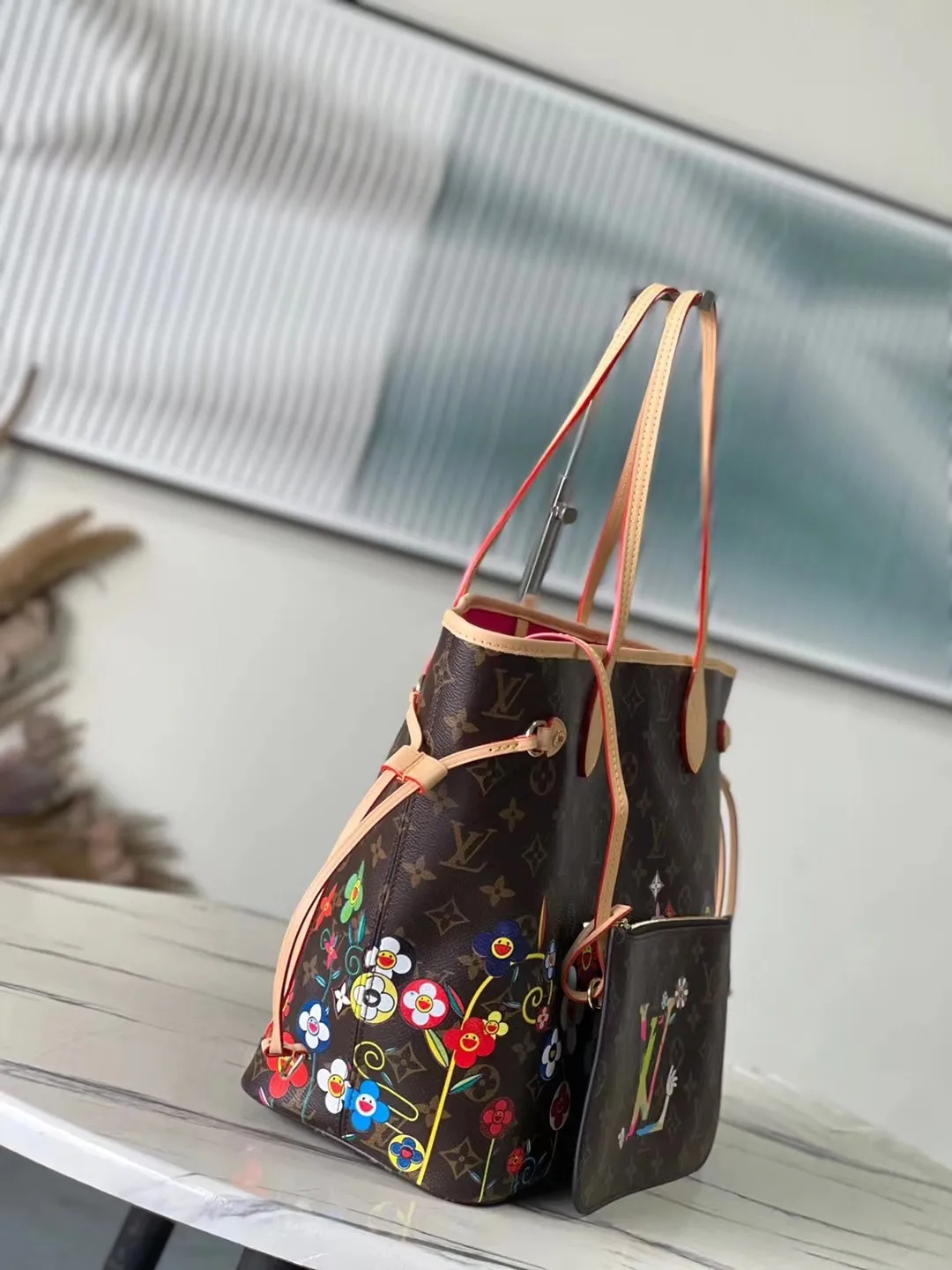 💰940 Top Original Order M13271 This medium-sized Neverfull handbag is from the Louis Vuitton x Takashi Murakami reissue series. It uses Monogram canvas to create a spacious configuration, and then uses the smart Monogram floral pattern to interpret the artist's "super flat" aesthetic style. Cowhide leather outlines the upper edge, handles and side straps, while the fabric lining incorporates colorful stripes. An interior zip pocket and a removable storage bag complete the functional design. Dimensions: 31 × 28 × 14 cm