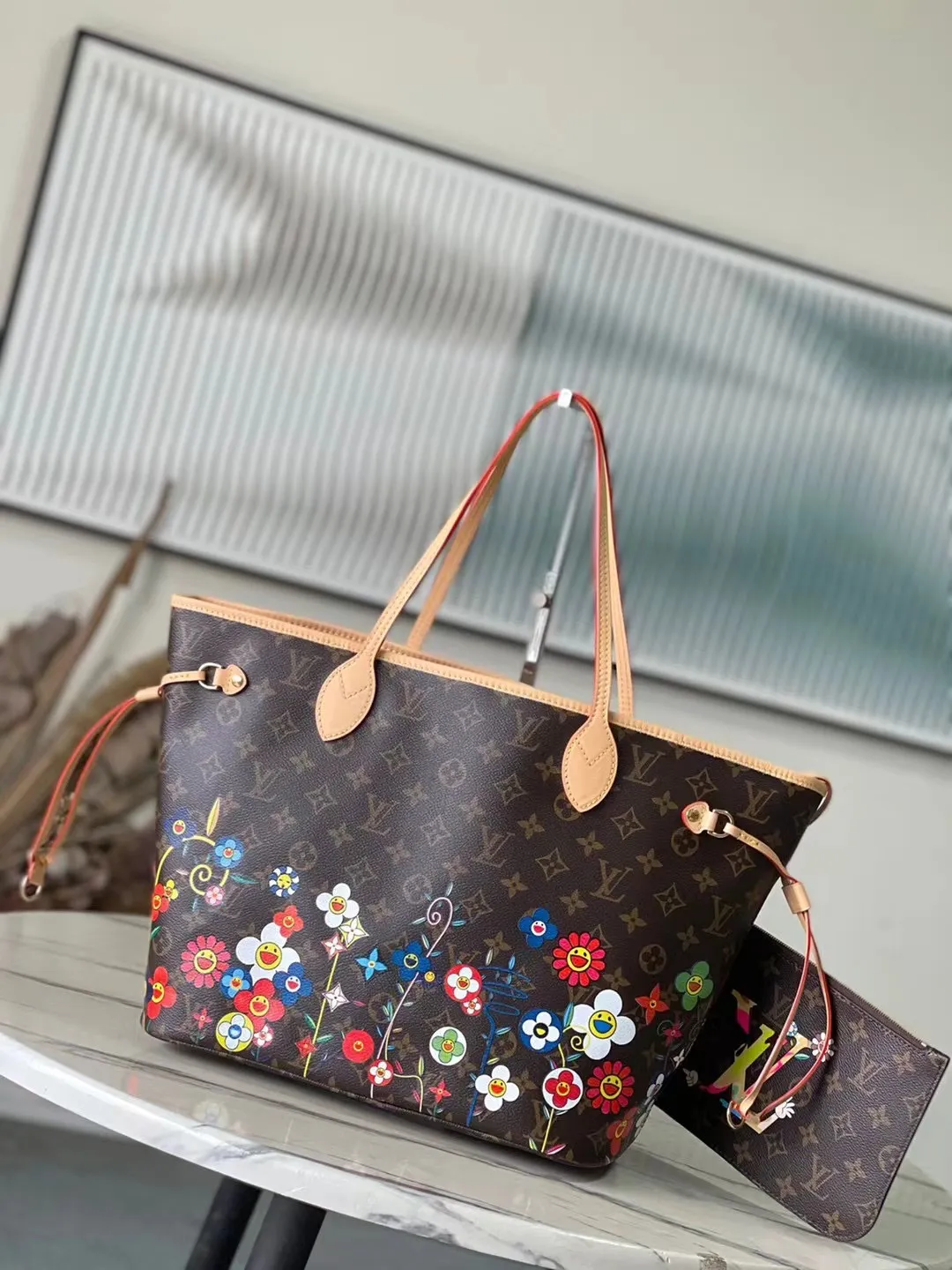 💰940 Top Original Order M13271 This medium-sized Neverfull handbag is from the Louis Vuitton x Takashi Murakami reissue series. It uses Monogram canvas to create a spacious configuration, and then uses the smart Monogram floral pattern to interpret the artist's "super flat" aesthetic style. Cowhide leather outlines the upper edge, handles and side straps, while the fabric lining incorporates colorful stripes. An interior zip pocket and a removable storage bag complete the functional design. Dimensions: 31 × 28 × 14 cm