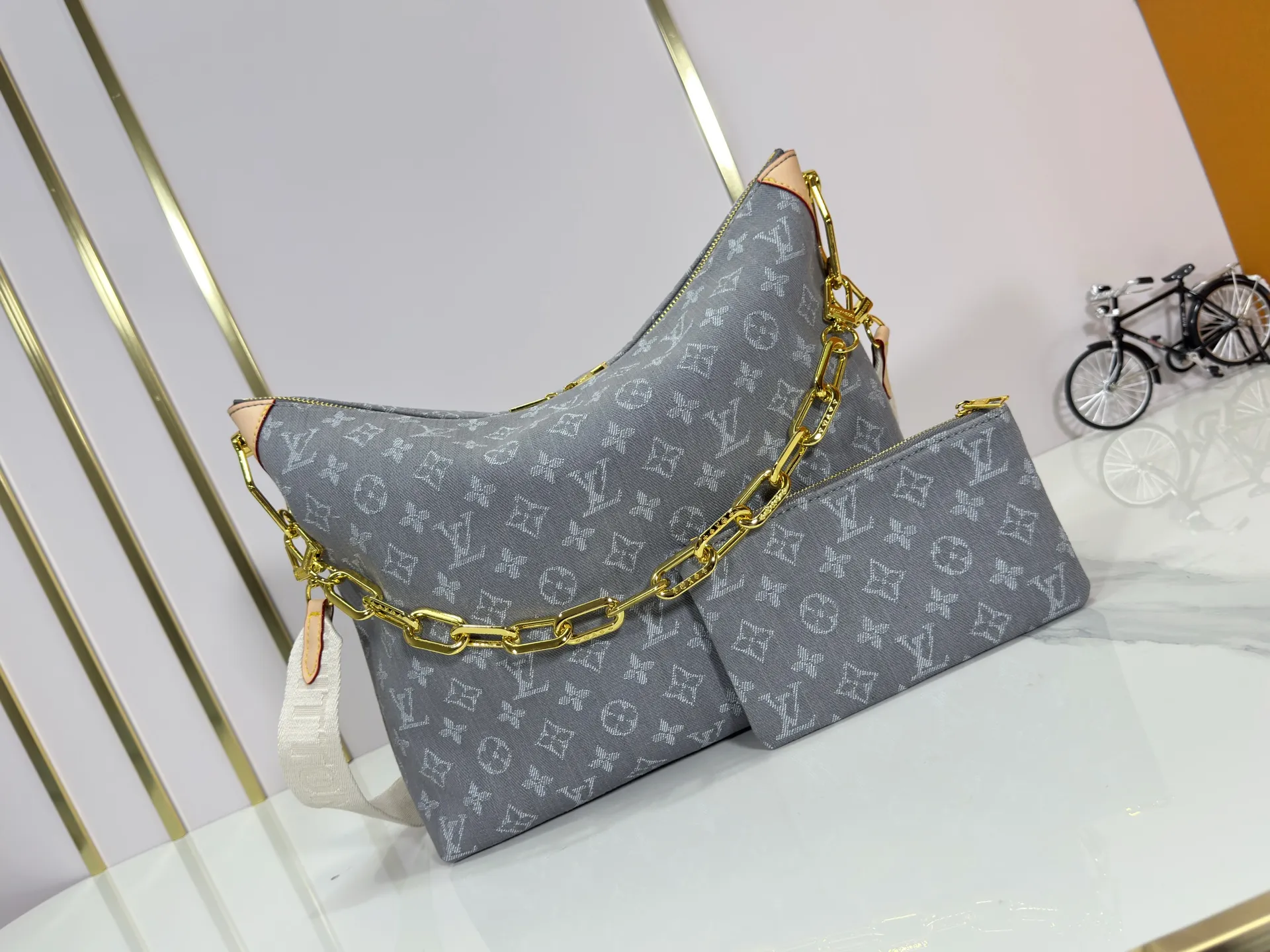 P260 Upgraded Original M13390 M12072 M12068 M12071 This Coussin Hobo MM handbag celebrates the return of the brand's iconic Monogram Denim pattern, originally launched in 2005. Made of organic cotton, it's woven from black and white yarns that have been faded to create a vintage look. Spacious, it's decorated with a light gold metallic finish and includes a removable pocket with a slide lock to securely store small items. This model can be worn crosswise, on the shoulder or on the hand. Dimensions: 38 x 33 x 10 cm