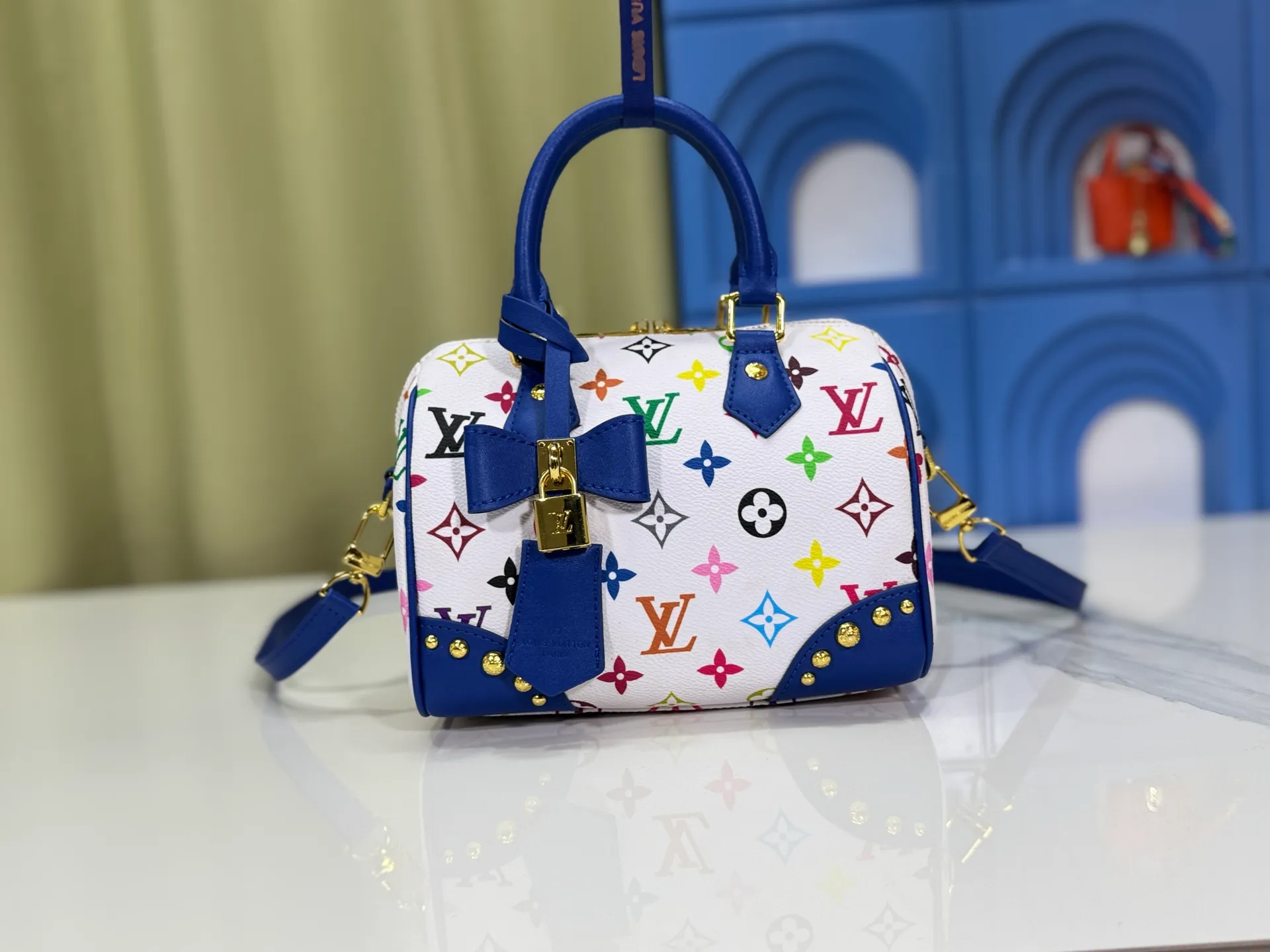 P280 upgraded original M58953 M46234 M46222 Speedy Bandoulière 20 handbag is made of soft coated canvas, and the full-length Monogram pattern is traced in colorful rainbow tones, highlighting the smart style of the Louis Vuitton x Murakami reissue series. The Toron handle and detachable shoulder strap are constructed of cow leather, the metal corners recall classic luggage elements, and the bow-shaped key bag and padlock add brand touches. Dimensions: 20.5 x 13.5 x 12.0 cm (length x height x width)
