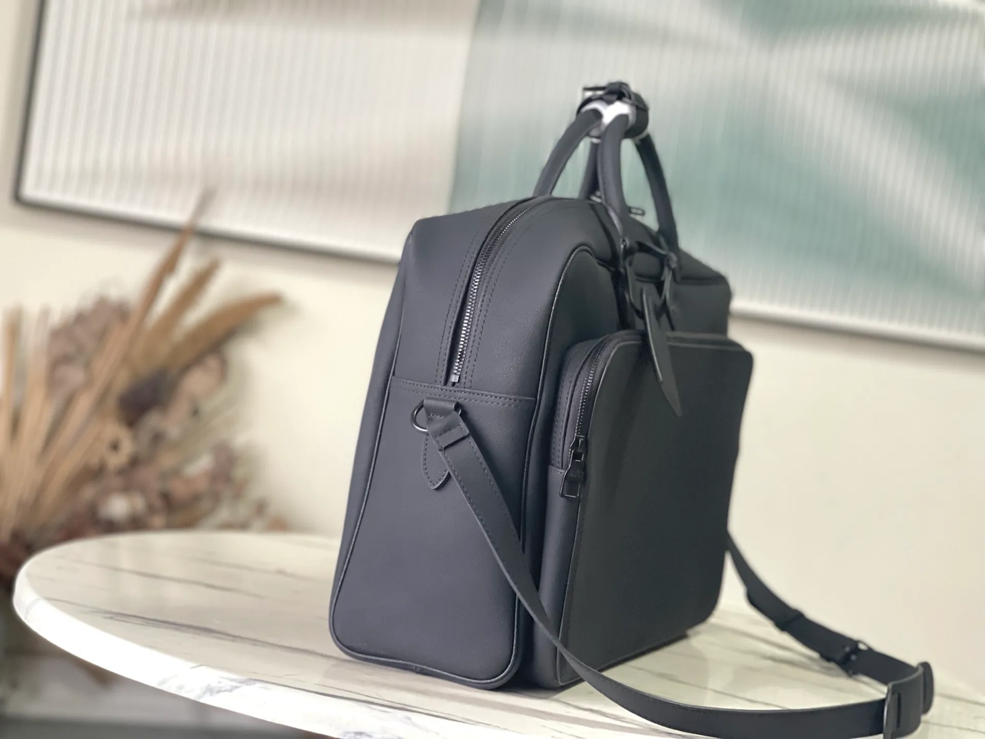💰1680 (first-grain leather) Top-quality original order M26075 This Weekender Bag handbag is made of waxed cow leather, lining of the same color and bright metal parts. Its size is just right to be placed on the top of the Horizon trolley suitcase, making business travel easy and comfortable. A roomy zippered front pocket expands the main compartment, while a top handle and removable and adjustable shoulder strap provide multiple carrying options. Dimensions: 46 × 31 × 8 cm