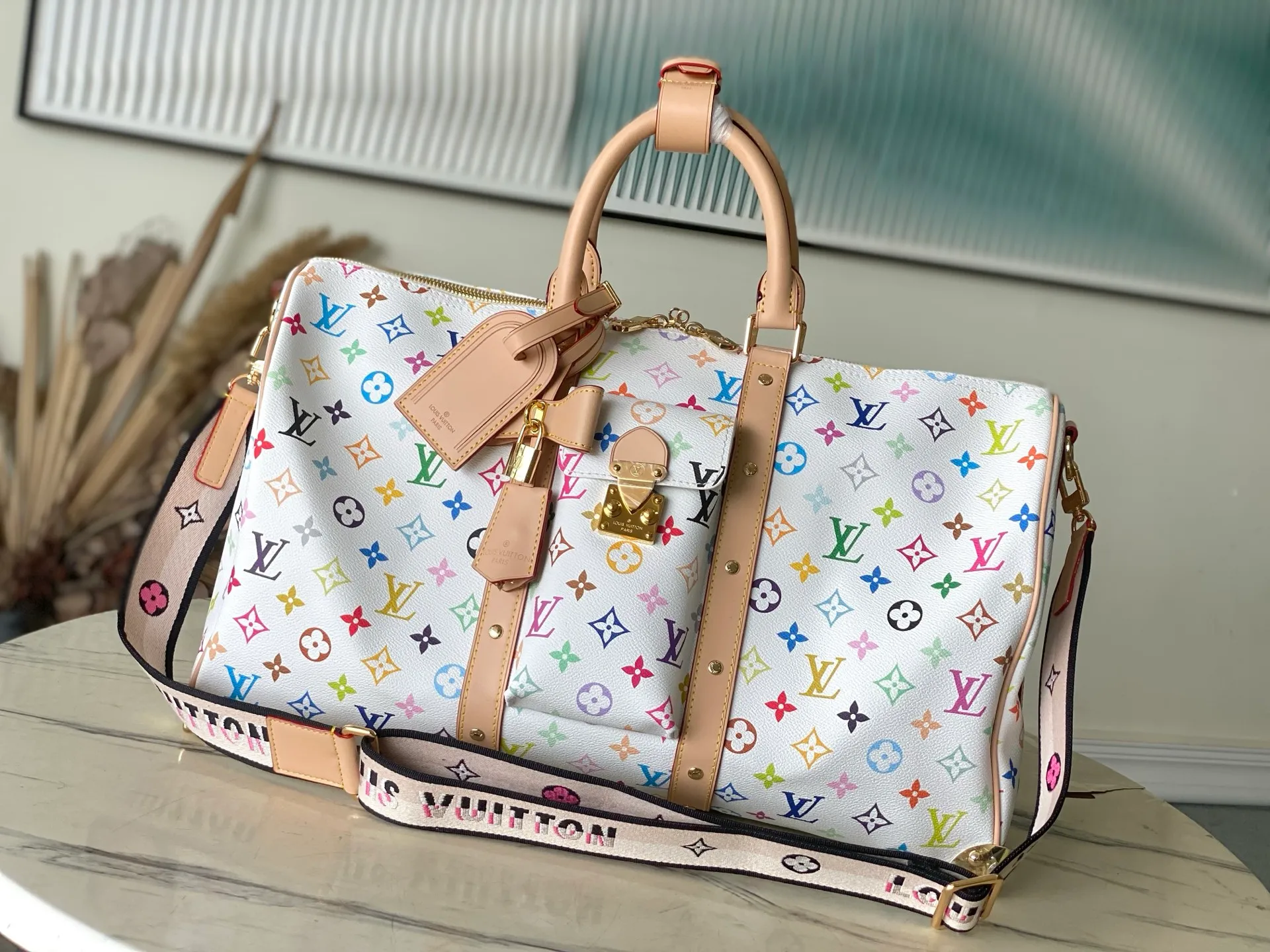 💰1560 Top original order M13742 Embroidered shoulder strap model This Keepal Bandouliere45 travel bag is from the Louis Vuitton × Murakami reissue series. It uses gorgeous Monogram coated canvas to show the creative blend of the brand's iconic elements and the artist's iridescent aesthetics. The S-lock buckle and glossy metal corners on the front pocket establish a classic foundation, while the rivet ribbon and bow-shaped key bag highlight the new season trend. Dimensions: 45 × 27 × 20 cm