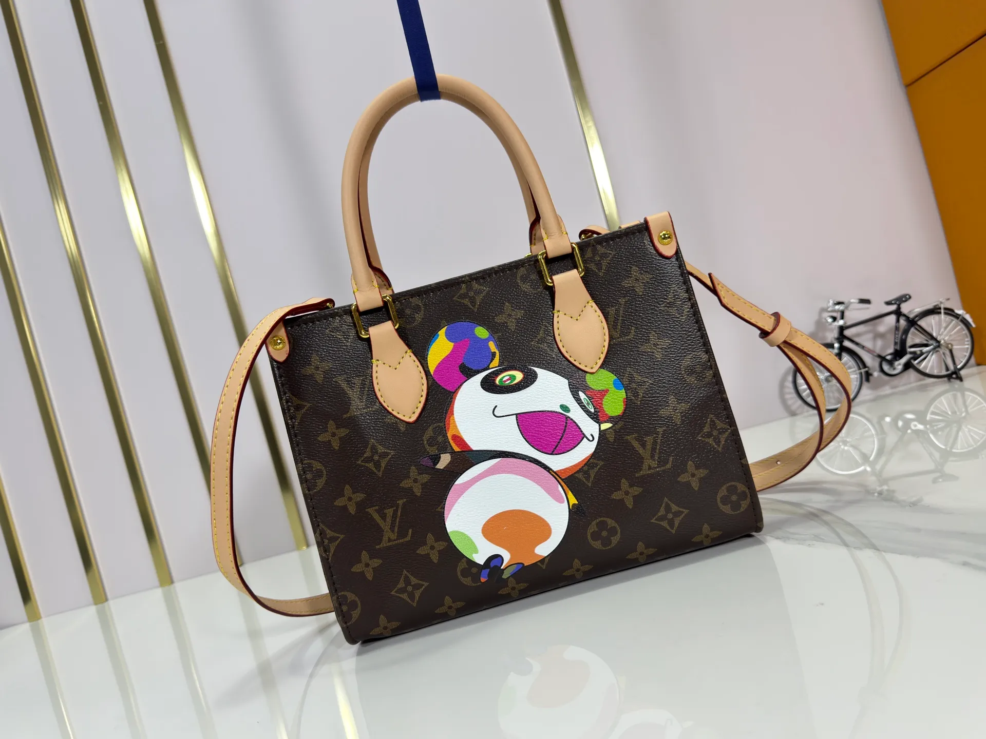 P240 upgraded original M45659 M46373 M13668 M44571 The Louis Vuitton x Murakami reissue series interprets the exquisite version of the OnTheGo handbag with playful touches. Monogram canvas and cow leather establish the brand's classic style, and Murakami's cute and cute panda image is transformed into front and back prints. The detachable and adjustable shoulder strap provides a variety of carrying options, and the zippered interior pocket keeps personal items safe and secure. Dimensions: 25.0 x 19.0 x 11.5 cm (length x height x width)