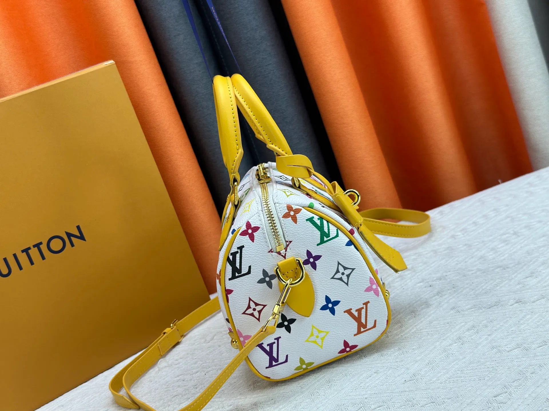 P260 upgraded original M58953 M46234 M46222 Speedy Bandoulière 20 handbag is made of soft coated canvas, and the full-length Monogram pattern is traced in colorful rainbow tones, highlighting the smart style of the Louis Vuitton x Murakami reissue series. The Toron handle and detachable shoulder strap are constructed of cow leather, the metal corners recall classic luggage elements, and the bow-shaped key bag and padlock add brand touches. Dimensions: 20.5 x 13.5 x 12.0 cm (length x height x width)