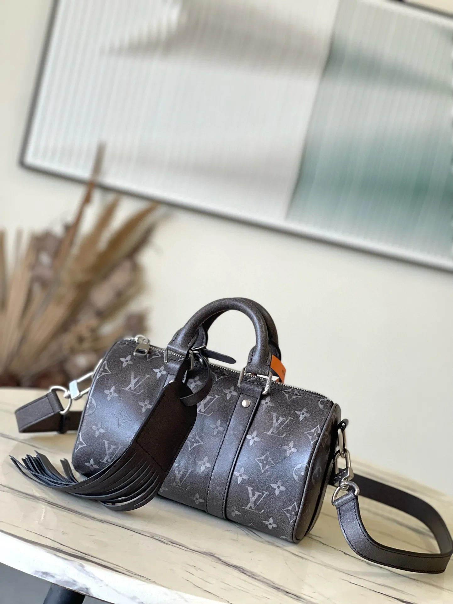 💰1020 Top Original M11595 This Keepal Bandouliere 25 handbag is made of Brushed Monogram cow leather, with a faded Monogram pattern to pay tribute to the old leather saddles used by Western cowboys. The leather name tag is equipped with long tassels, highlighting the From Paris to Virginia theme of the Pharrel Williams 2024 autumn and winter series. Dimensions: 25 × 15 × 11 cm
