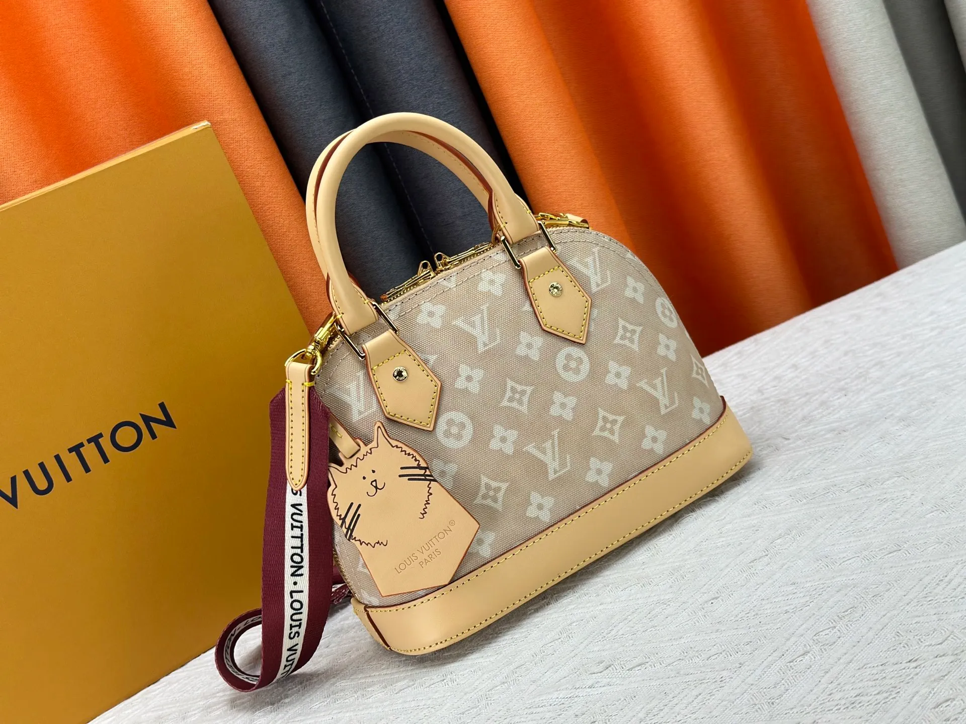 P260 Alma BB handbag M99021 M82348 M53152 M25728 M53151 A creative work of Louis Vuitton's Catogram series, the Alma BB handbag is made of light beige denim material and is engraved with the brand's iconic Monogram pattern, showing a retro style. Paired with beige leather trim and gold hardware, the classic shell bag shape incorporates cute cat charms, injecting vitality into the overall look. Equipped with a detachable shoulder strap, it can be carried by hand or cross-body to meet a variety of dressing needs. From daily outings to casual luxury socializing, it combines retro texture and cute design to become an eye-catching item that shows personality and taste. It is a fashionable choice for those who love cute style and classic design. Size: 23.5x17x11cm