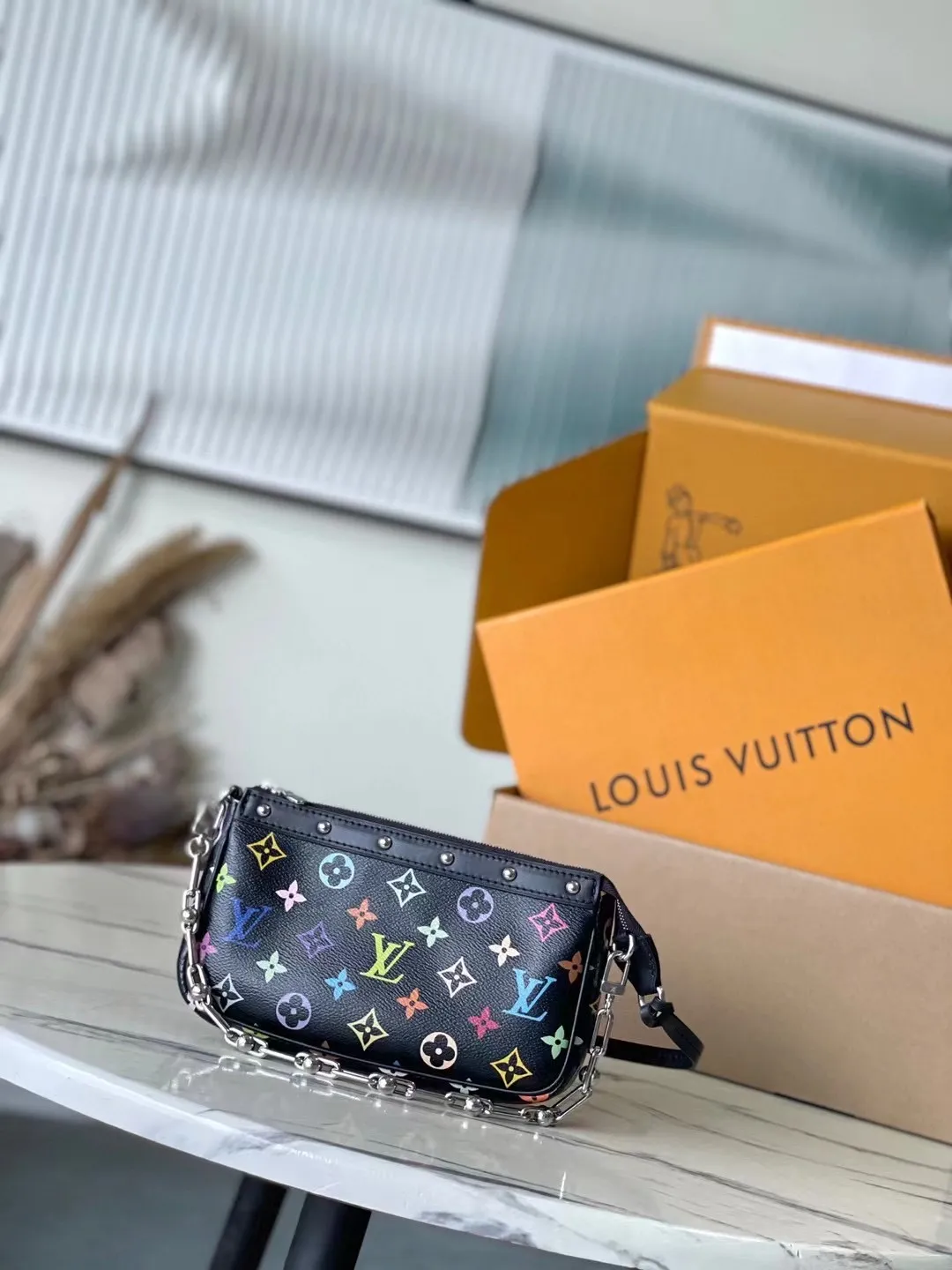 💰880 Top Original Order M13663 Black Color This Pochette Accessoires handbag is made of coated canvas and uses colorful Monogram patterns to interpret the smart style of the Louis Vuitton x Murakami cross-border collaboration series. Calf leather trim and dazzling hardware add to the sophisticated details, while the detachable shoulder strap and chain allow for flexible carry. 13 x 4 x 22 cm (height x width x length)