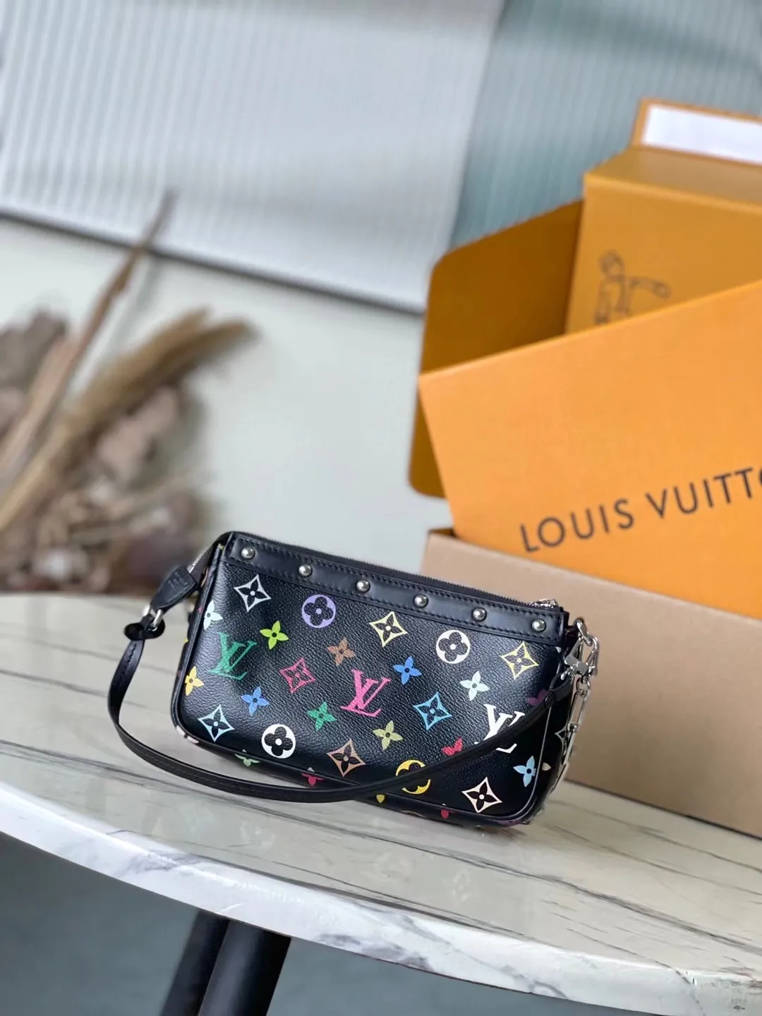 💰880 Top Original Order M13663 Black Color This Pochette Accessoires handbag is made of coated canvas and uses colorful Monogram patterns to interpret the smart style of the Louis Vuitton x Murakami cross-border collaboration series. Calf leather trim and dazzling hardware add to the sophisticated details, while the detachable shoulder strap and chain allow for flexible carry. 13 x 4 x 22 cm (height x width x length)