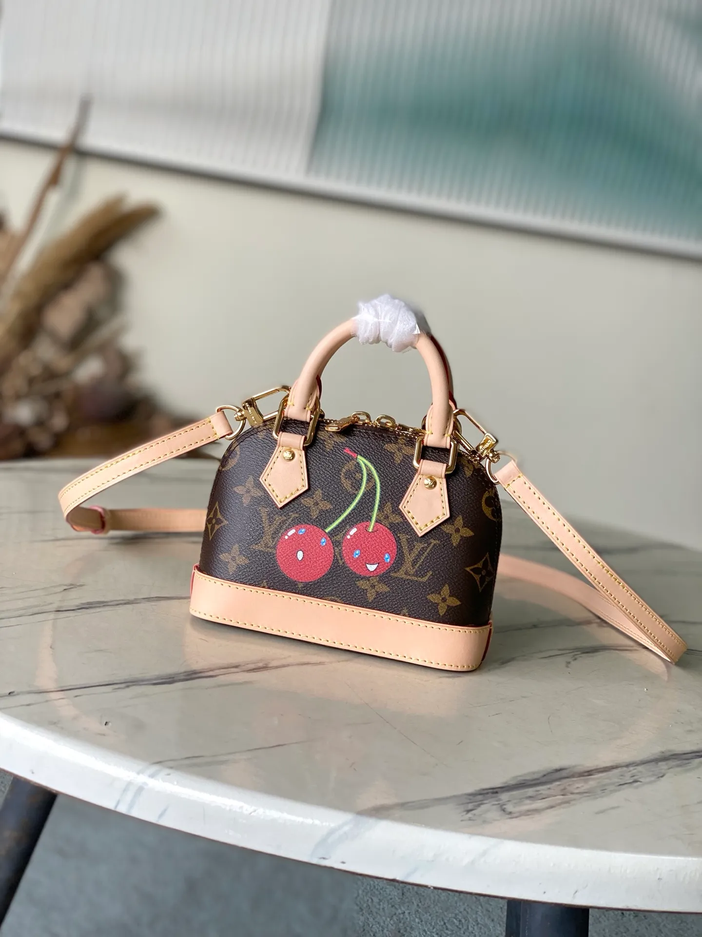 💰1100 Top Original Order M13416 This Nano Alma handbag combines Monogram coated canvas and cow leather trim, making the exquisite silhouette show the cherry pattern of the Louis Vuitton × Murakami replica series. The top handle and detachable and adjustable shoulder strap allow for a variety of carrying methods, and the internal space can accommodate daily needs such as a short wallet and a large smartphone. Dimensions: 18 × 12 × 8 cm