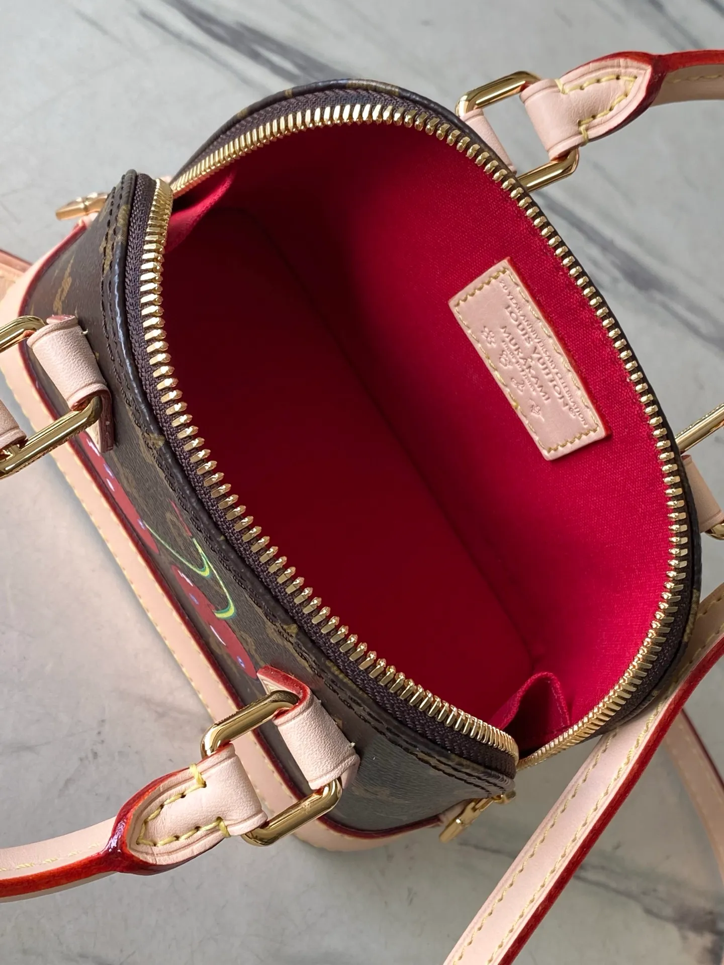 💰1100 Top Original Order M13416 This Nano Alma handbag combines Monogram coated canvas and cow leather trim, making the exquisite silhouette show the cherry pattern of the Louis Vuitton × Murakami replica series. The top handle and detachable and adjustable shoulder strap allow for a variety of carrying methods, and the internal space can accommodate daily needs such as a short wallet and a large smartphone. Dimensions: 18 × 12 × 8 cm