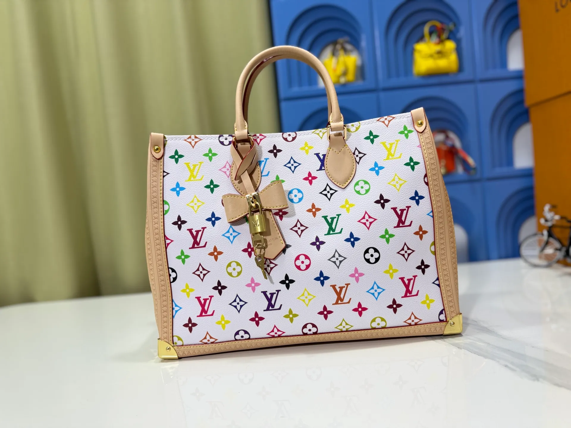 P340 upgrades the original M13079 Louis Vuitton x Takashi Murakami reissue series to interpret the OnTheGo medium handbag in a smart way. The colorful Monogram canvas body, cowhide leather trim and LV x TM key bag highlight the sophisticated style. The shiny corners recall the design of traditional Louis Vuitton luggage, and the shoulder strap and top handle allow for multiple carrying methods. Dimensions: 35.0 x 27.0 x 14.0 cm (length x height x width)