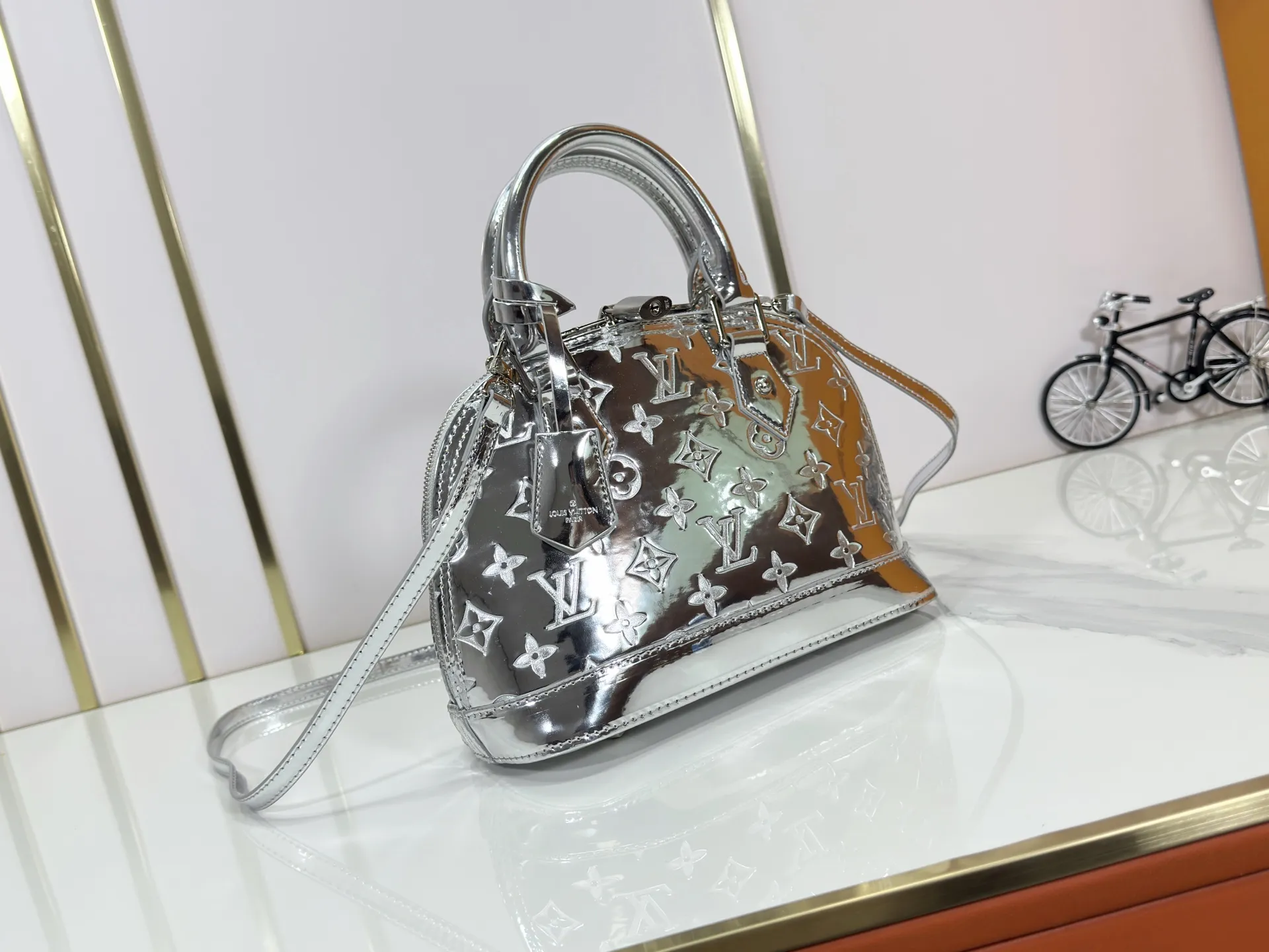 P240 M11835 M53151 M53152 The Alma medium handbag in the LVSki series draws inspiration from the Louis Vuitton archive hard box, rendering the Monogram embossed coated canvas with a new Monogram Miroir effect, highlighting the concept of retro futurism. Spacious interior patch pockets ensure organized storage. Size: 23.5x17.5x11.5cm