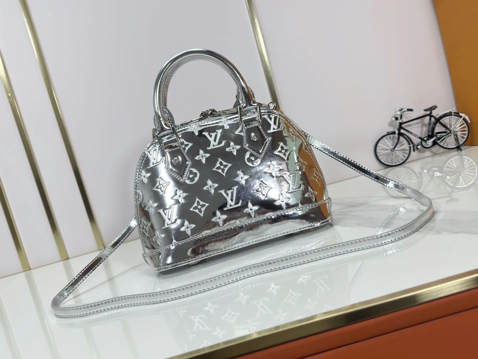 P240 M11835 M53151 M53152 The Alma medium handbag in the LVSki series draws inspiration from the Louis Vuitton archive hard box, rendering the Monogram embossed coated canvas with a new Monogram Miroir effect, highlighting the concept of retro futurism. Spacious interior patch pockets ensure organized storage. Size: 23.5x17.5x11.5cm