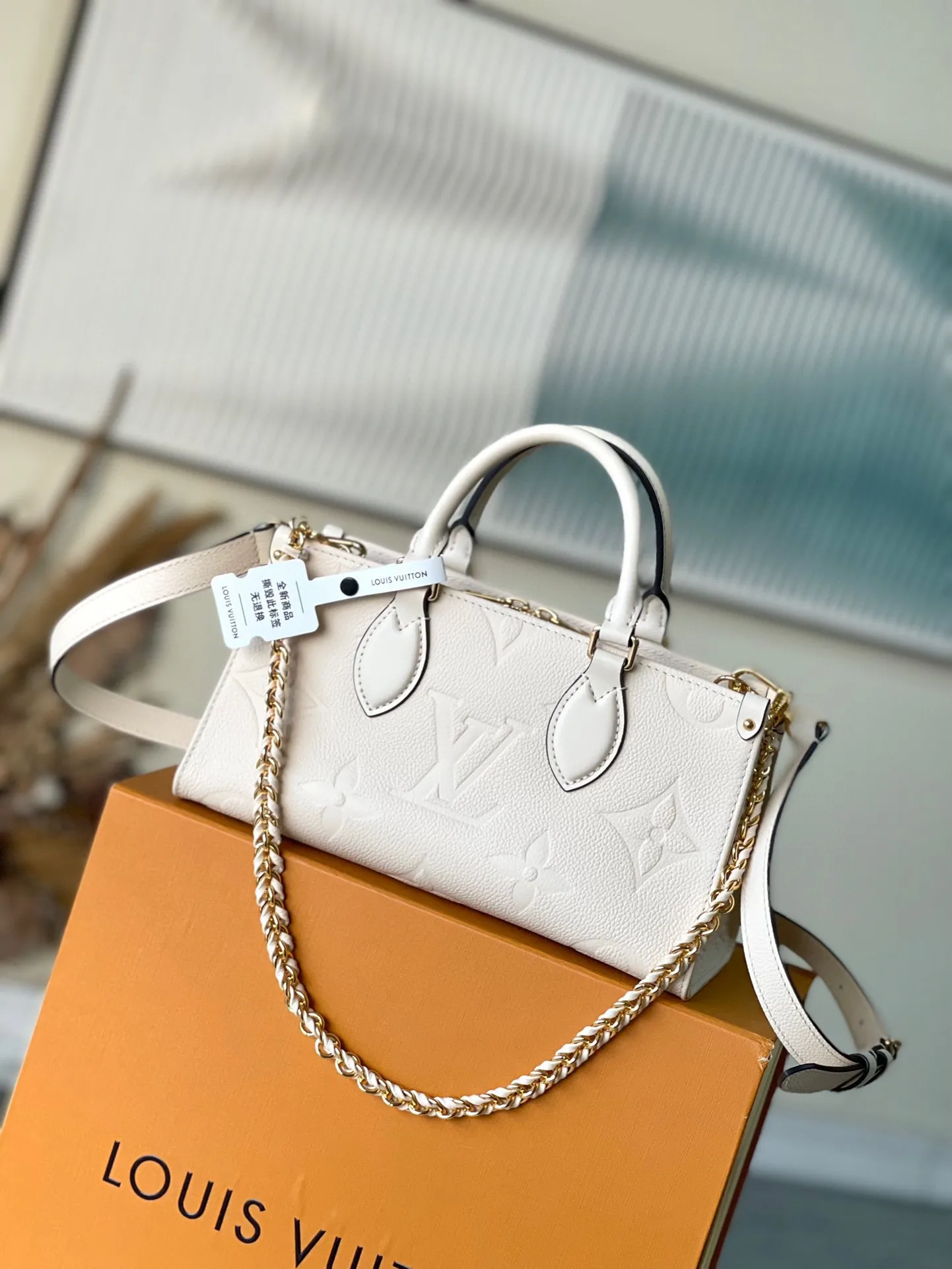 💰1060 (first-grain leather) top original order M23698 white This OnTheGo East West handbag introduces the OnTheGo small tote bag design. It uses Monogram Empreinte leather to reinterpret East West's ample configuration. Giant Monogram is embossed on the leather bag body. The neat inner layer can store daily necessities. The top handle and detachable leather chain shoulder strap allow for multiple carrying methods. Size: 25x13x10cm