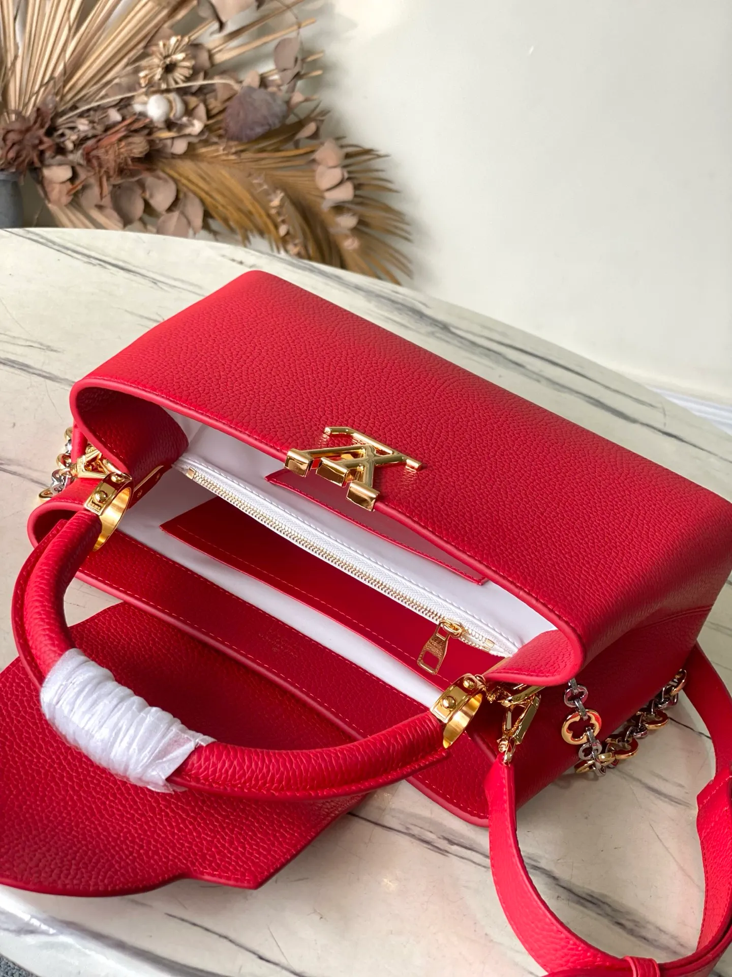 💰2480 "Special Grade Original Leather" M12935 Red Medium This Capucines medium handbag is from the Chain On You series. It uses Taurillon cow leather to focus on the brand's ingenuity and sophisticated craftsmanship. The jewelry-style double-plated chain is embellished with Monogram flowers, and the rounded LV letters and metal parts add elegant touches. Whether worn cross-body, hand-carried or shoulder-carried, it can display elegant style. Dimensions: 31.5 × 20 × 11 cm
