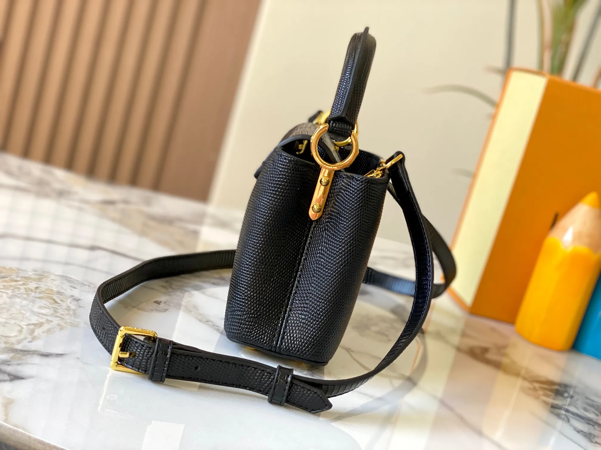 Top original P420 Guangzhou product M99527 black lizard gold buckle This Capucines mini handbag is wrapped in gorgeous lizard leather and lined with fine sheepskin, embellished with dazzling metal parts. The flip cover reads LV letters inside, and a Monogram flower blooms when turned out. Its compact size makes it a dazzling choice for evening occasions. Detailed features 21 x 14 x 8 cm (length x height x width)