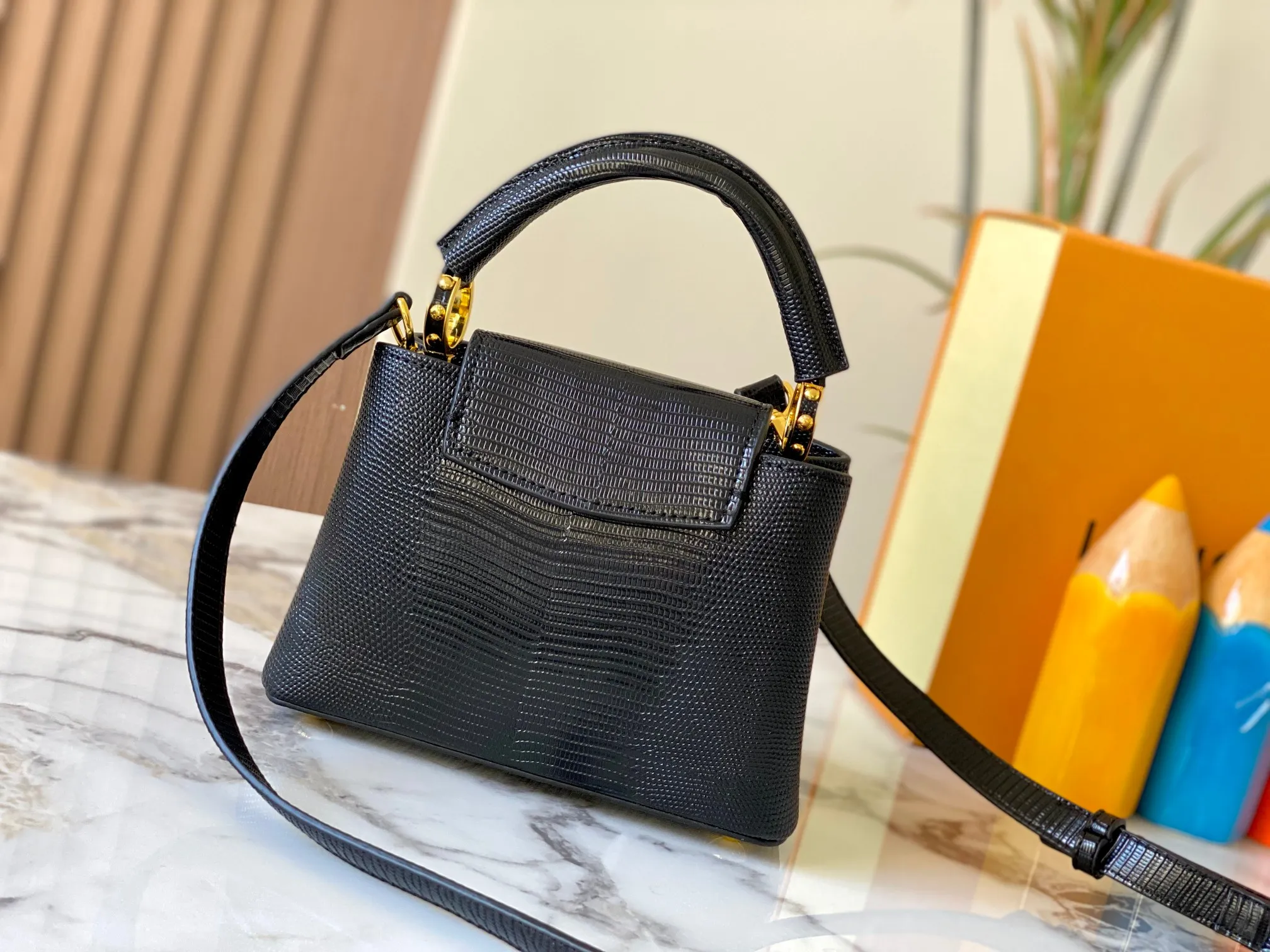 Top original P420 Guangzhou product M99527 black lizard gold buckle This Capucines mini handbag is wrapped in gorgeous lizard leather and lined with fine sheepskin, embellished with dazzling metal parts. The flip cover reads LV letters inside, and a Monogram flower blooms when turned out. Its compact size makes it a dazzling choice for evening occasions. Detailed features 21 x 14 x 8 cm (length x height x width)