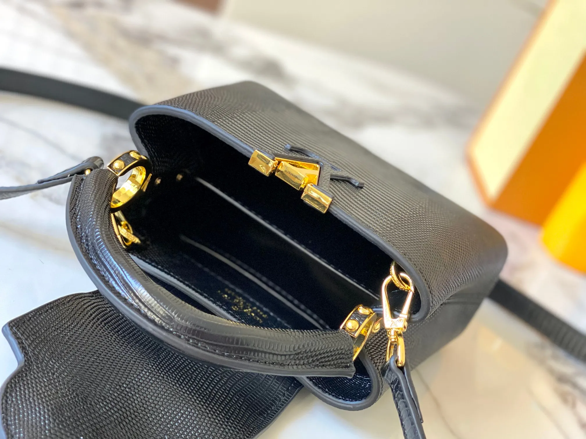 Top original P420 Guangzhou product M99527 black lizard gold buckle This Capucines mini handbag is wrapped in gorgeous lizard leather and lined with fine sheepskin, embellished with dazzling metal parts. The flip cover reads LV letters inside, and a Monogram flower blooms when turned out. Its compact size makes it a dazzling choice for evening occasions. Detailed features 21 x 14 x 8 cm (length x height x width)