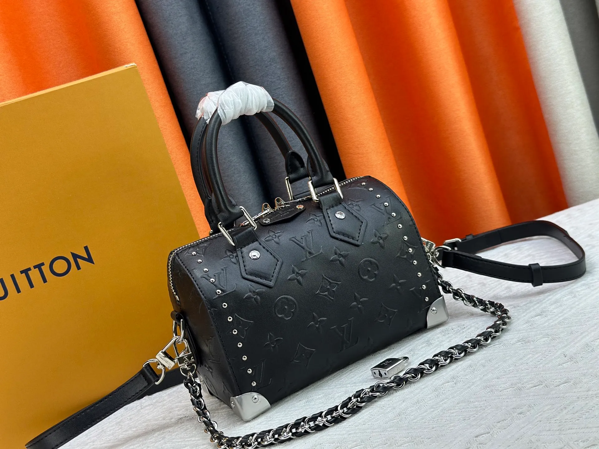 The P300 M13146 M14575 Speedy Trunk handbag reimagines the classic design with a bold concept and made an eye-catching appearance at the Louis Vuitton 2025 Cruise early spring show. Monogram canvas with Monogram Reverse trim shows Nicolas Ghesquière’s signature brushwork, and the dazzling metal hardware pays homage to the brand’s long trunk-making heritage. The shoulder strap and chain are detachable and can be worn cross-body, over the shoulder or by hand. Detailed Features 20.5x16 x11 cm (Length x Height x Width) Monogram canvas Cow leather trim Fabric lining Metal hardware Padlock Internal patch pocket Chain: Removable Chain half length: 13.0 cm Handle: Double handle