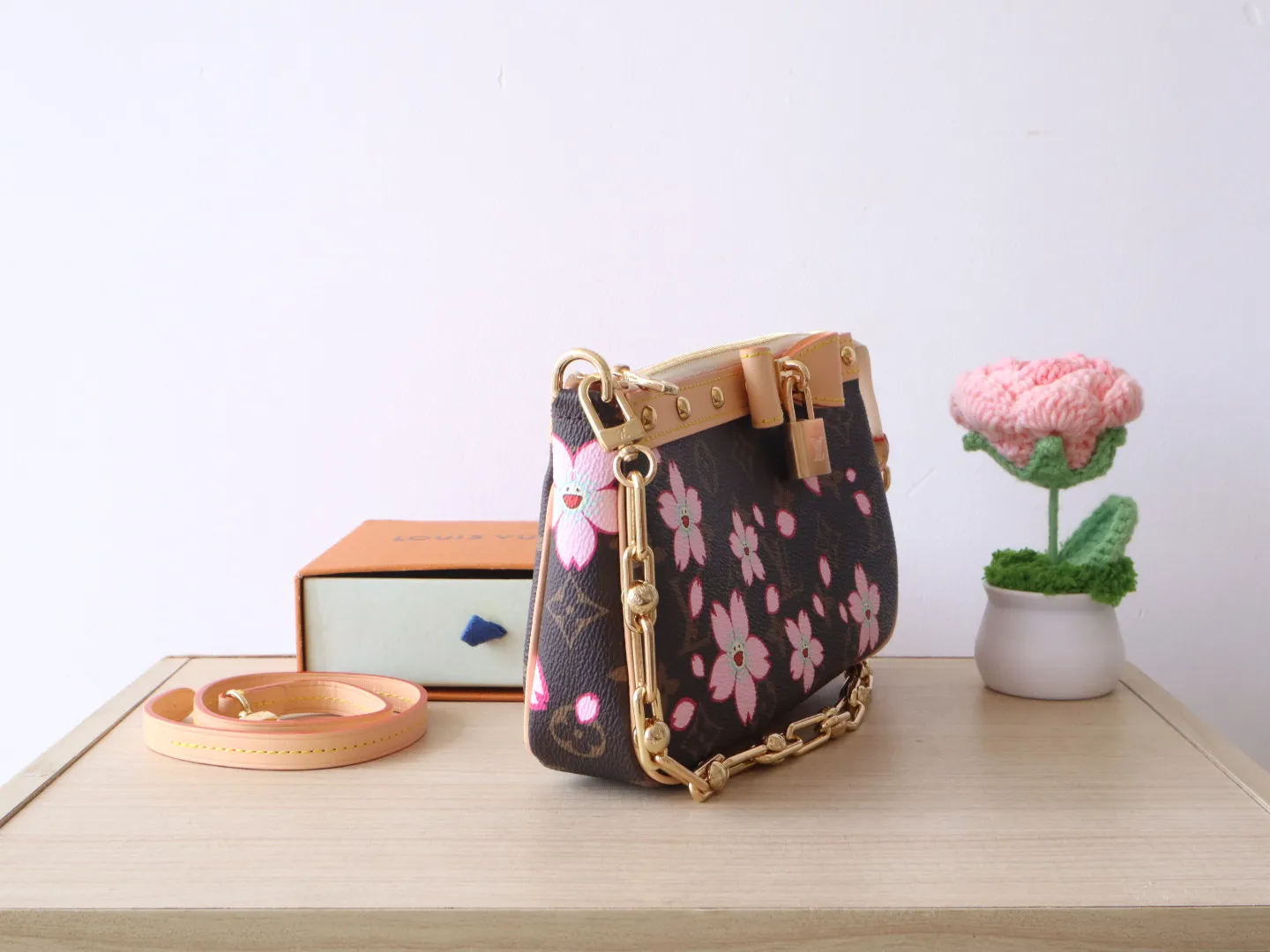 M13666 Cherry Blossom 🌟P740 This Pochette Accessoires handbag is made of classic Monogram canvas with the bright Cherry Blossom pattern written by Takashi Murakami, which expresses the distinctive elements of the Louis Vuitton x Takashi Murakami replica series in a playful style. A leather bow and LV-engraved padlock accent the upper edge, while dazzling studs and a detachable chain add a touch of irreverence. 13 x 4 x 22 cm