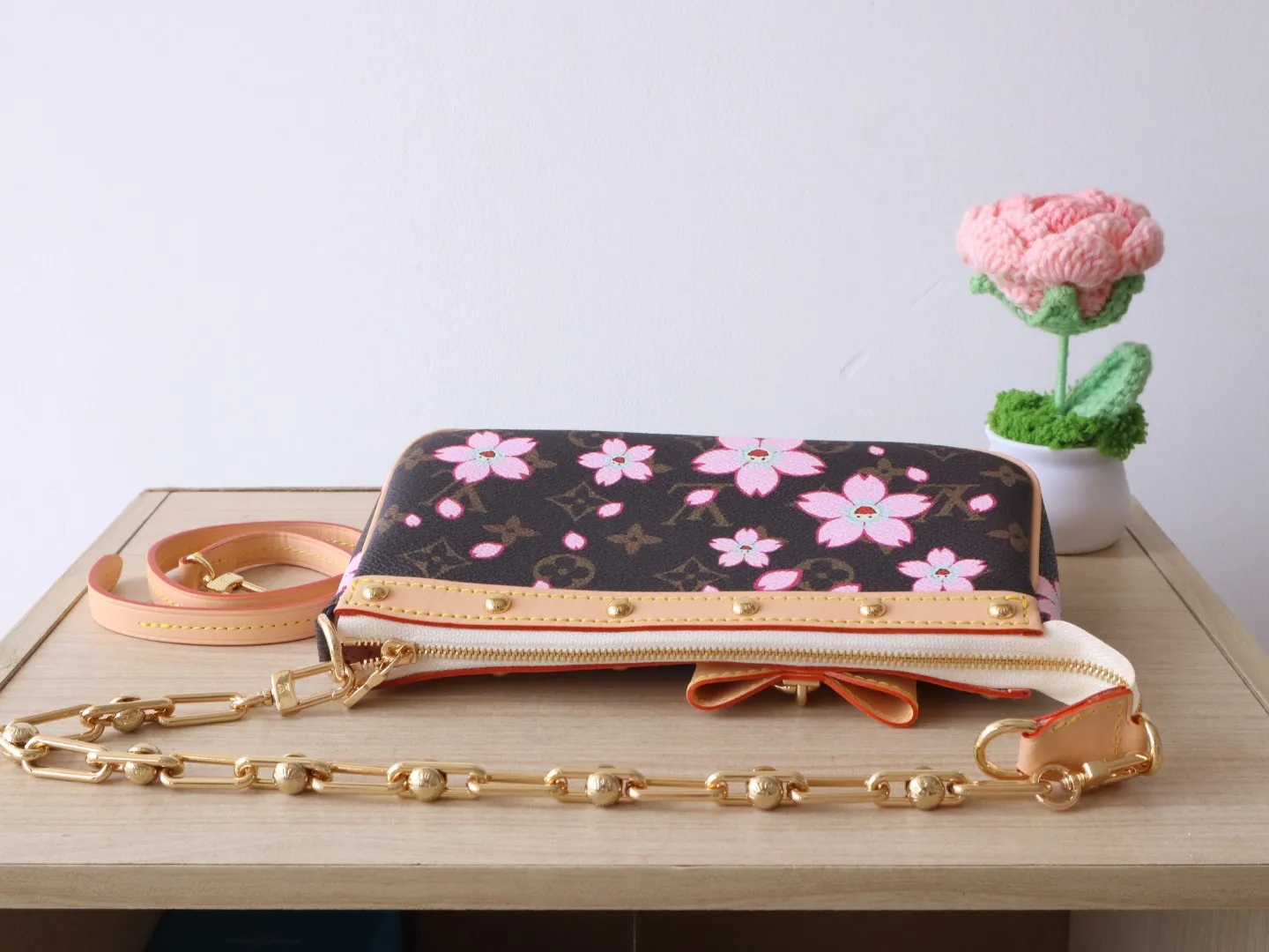 M13666 Cherry Blossom 🌟P740 This Pochette Accessoires handbag is made of classic Monogram canvas with the bright Cherry Blossom pattern written by Takashi Murakami, which expresses the distinctive elements of the Louis Vuitton x Takashi Murakami replica series in a playful style. A leather bow and LV-engraved padlock accent the upper edge, while dazzling studs and a detachable chain add a touch of irreverence. 13 x 4 x 22 cm