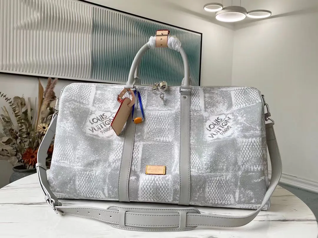 💰1220 Top Original N50069 Gray KEEPALL BANDOULIÈRE 50 Travel Bag This Keepall BANDOULIÈRE travel bag is made of Damier Salt canvas. It adopts the distressing process used for denim in the ready-to-wear series to treat the classic coated canvas. The large plaid denim pattern old screen-printed travel bag gives the large plaid a rough texture. The generous capacity lives up to its name, making it perfect for weekend getaways or short trips. Detailed features50 x 29 x 23 cm