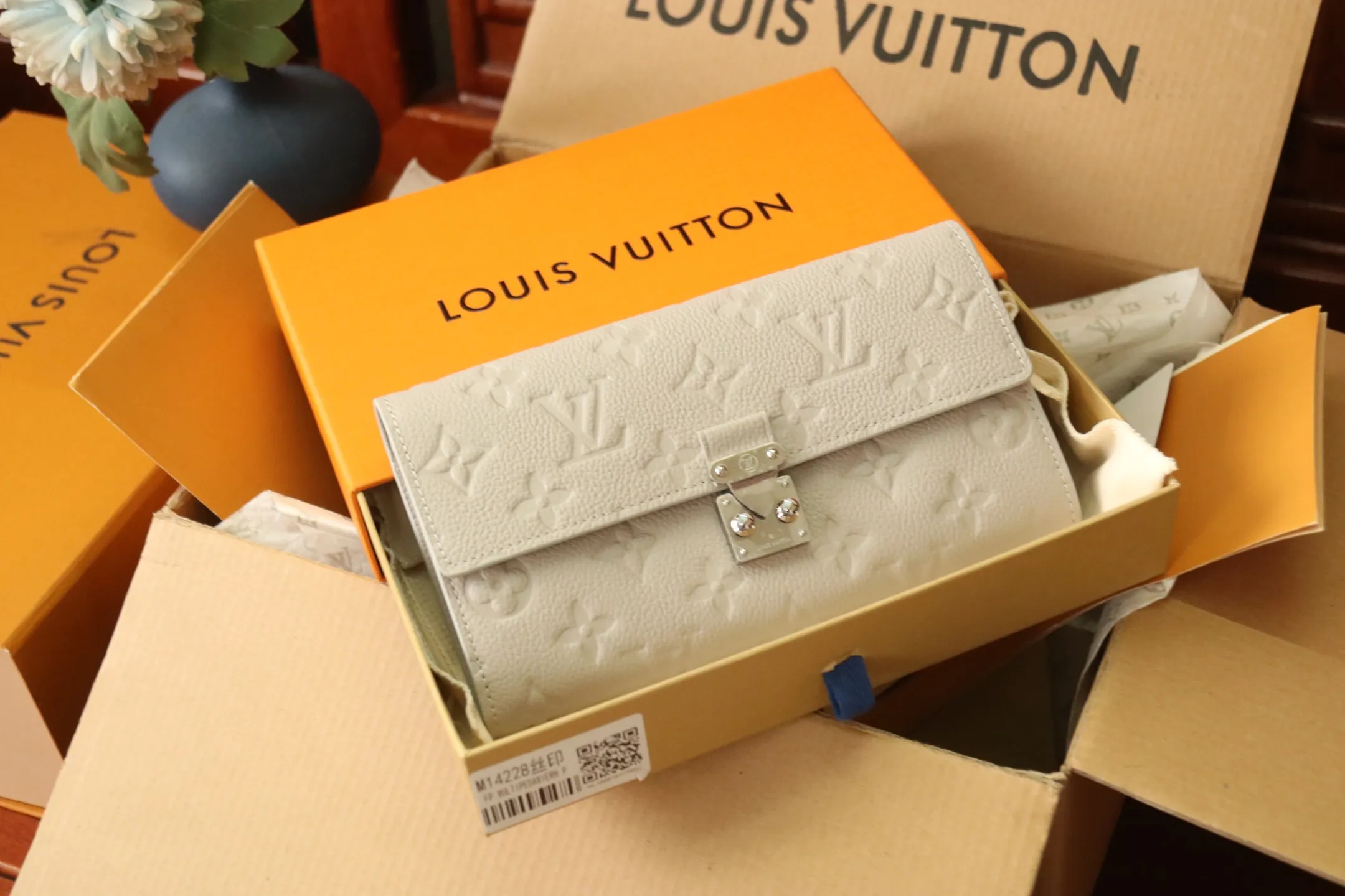 M13463 Gray 🌟 "Portefeuille Sara Metis" in P600 leather. The flaps are decorated with golden S-lock style buttons inspired by Louis Vuitton’s traditional trunks that symbolize “Métis”. It features an elegant rectangular shape and multiple pockets, as well as a spacious interior with compartments and card slots.  19 x 11 x 3cm