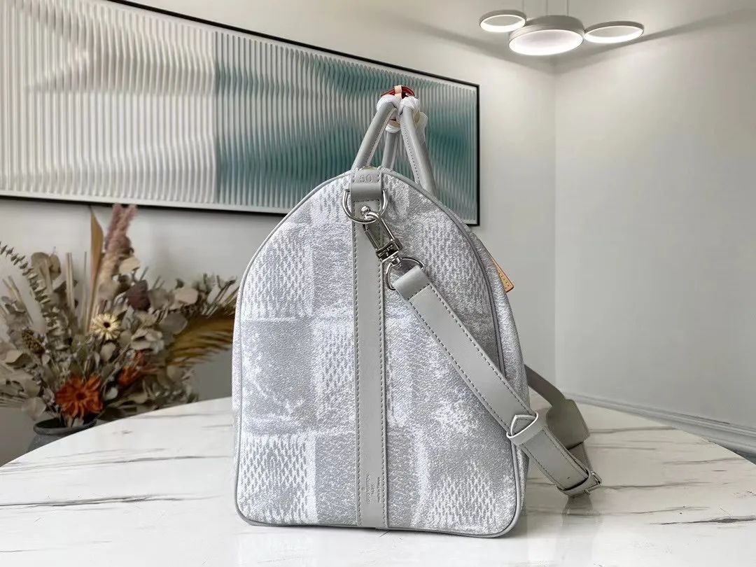 💰1220 Top Original N50069 Gray KEEPALL BANDOULIÈRE 50 Travel Bag This Keepall BANDOULIÈRE travel bag is made of Damier Salt canvas. It adopts the distressing process used for denim in the ready-to-wear series to treat the classic coated canvas. The large plaid denim pattern old screen-printed travel bag gives the large plaid a rough texture. The generous capacity lives up to its name, making it perfect for weekend getaways or short trips. Detailed features50 x 29 x 23 cm