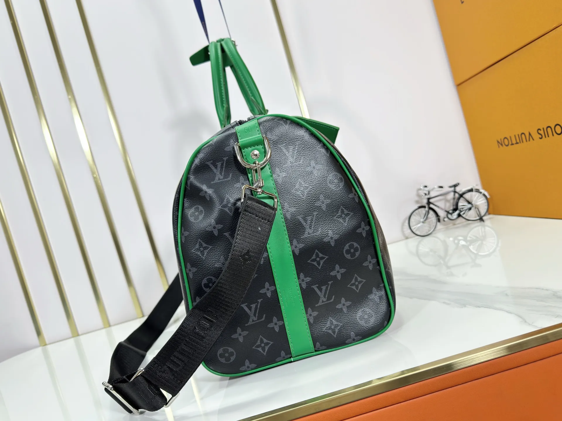 P340 M26434 M41416 Upgraded from the original version, this Keepall Bandoulière 50 travel bag is made of Monogram Eclipse canvas, with bright side straps and top handles to inject a dynamic feel. Compact construction with fabric lining and zippered pockets for on-the-go convenience. The removable and adjustable shoulder strap allows for shoulder or cross-body wear. 29 x 23 x 50 cm (height x width x length)