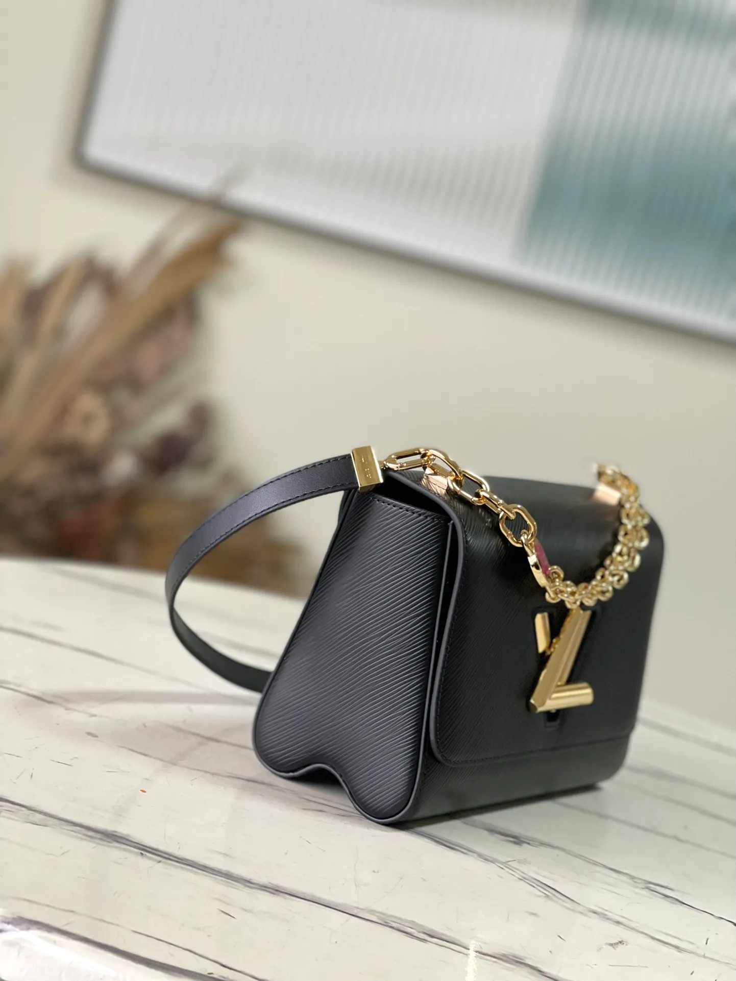 💰1160 (First-Grade Leather) Top Original M21606 Black This Twist medium handbag incorporates an enamel Monogram flower into the double chain, which can be used as a subtle embellishment or connected to the shoulder strap to achieve more styling possibilities. Epi grained leather body with smooth leather trim and lining. Dimensions: 23 x 17 x 9.5 cm