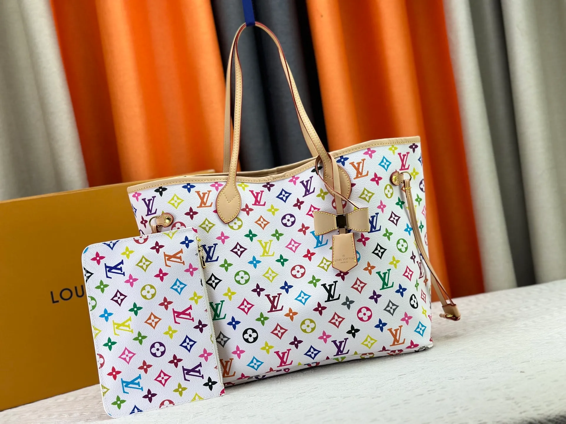 P260 Upgraded original M13675 M13271 M40995 This medium-sized Neverfull handbag is from the Louis Vuitton x Takashi Murakami reissue series. It uses Monogram canvas to create a spacious configuration, and then uses the smart Monogram floral pattern to interpret the artist's "ultra-flat" aesthetic style. Cowhide leather outlines the upper edge, handles and side straps, while the fabric lining incorporates colorful stripes. An interior zip pocket and a removable storage bag complete the functional design. Dimensions: 31.0 x 28.0 x 14.0 cm (length x height x width)