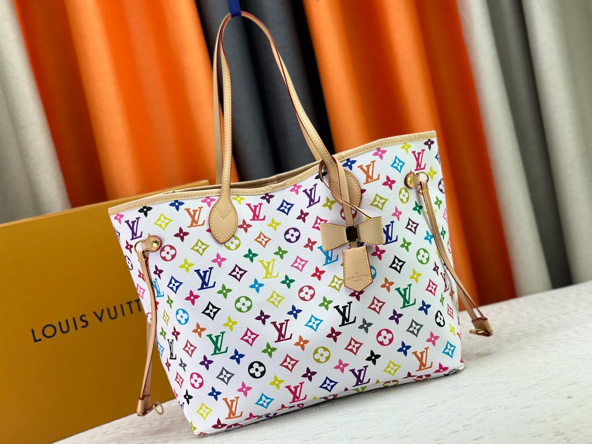 P260 Upgraded original M13675 M13271 M40995 This medium-sized Neverfull handbag is from the Louis Vuitton x Takashi Murakami reissue series. It uses Monogram canvas to create a spacious configuration, and then uses the smart Monogram floral pattern to interpret the artist's "ultra-flat" aesthetic style. Cowhide leather outlines the upper edge, handles and side straps, while the fabric lining incorporates colorful stripes. An interior zip pocket and a removable storage bag complete the functional design. Dimensions: 31.0 x 28.0 x 14.0 cm (length x height x width)
