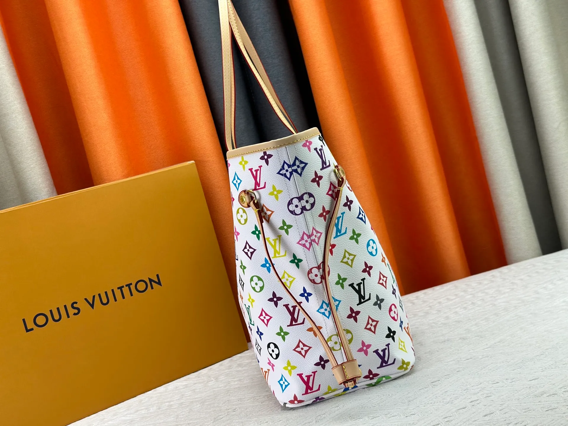 P260 Upgraded original M13675 M13271 M40995 This medium-sized Neverfull handbag is from the Louis Vuitton x Takashi Murakami reissue series. It uses Monogram canvas to create a spacious configuration, and then uses the smart Monogram floral pattern to interpret the artist's "ultra-flat" aesthetic style. Cowhide leather outlines the upper edge, handles and side straps, while the fabric lining incorporates colorful stripes. An interior zip pocket and a removable storage bag complete the functional design. Dimensions: 31.0 x 28.0 x 14.0 cm (length x height x width)