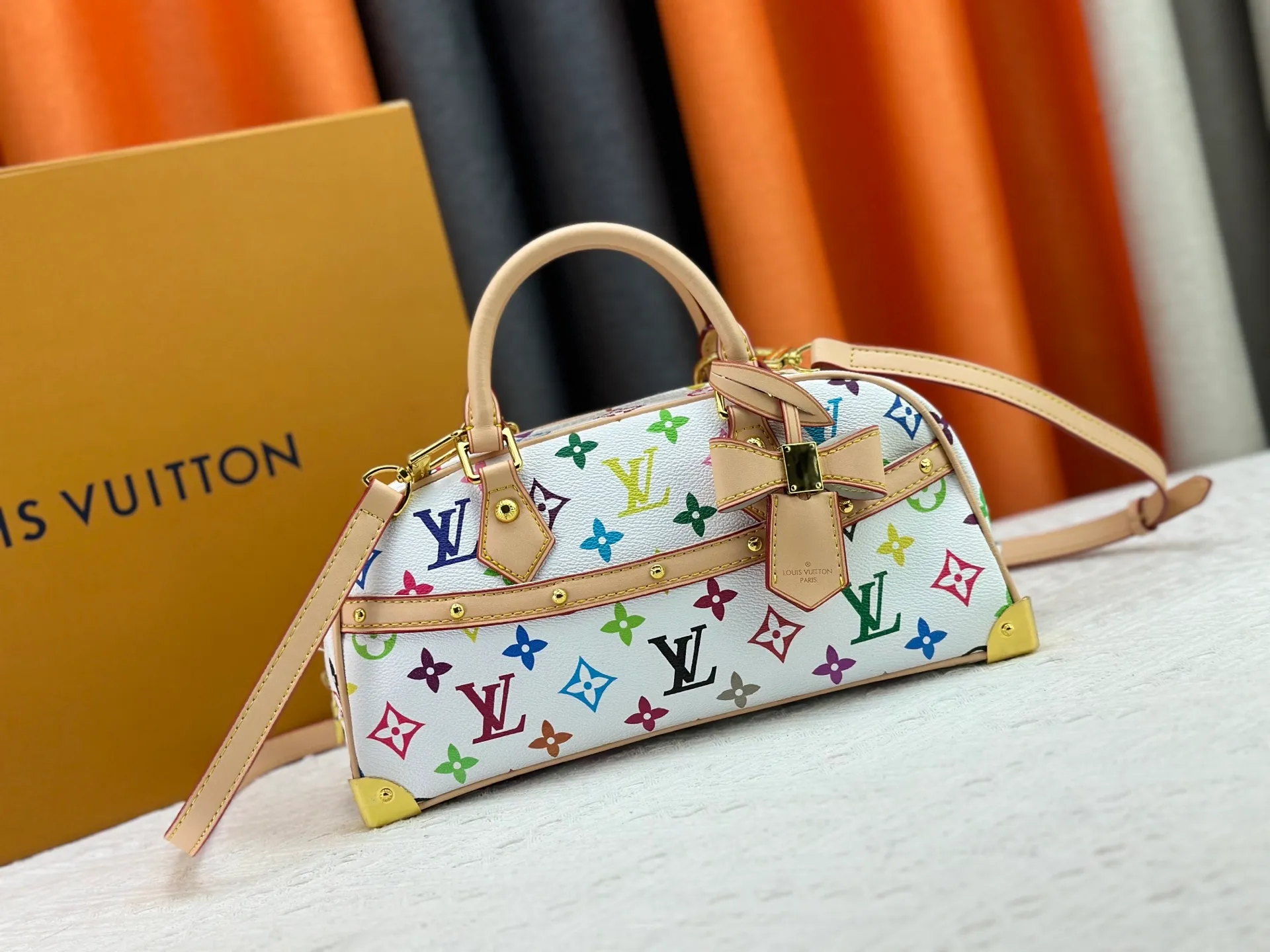P280 Upgraded Original M13084 This Handbag East West handbag is from the Louis Vuitton x Takashi Murakami reissue series, using the artist's signature rainbow tones to trace the full-length Monogram pattern. Sleek horizontal construction lines the top handle, studded side straps, detachable and adjustable shoulder strap and LV x TM key holder, with cowhide leather details and sophisticated corners that nod to the brand's traditional luggage. Dimensions: 27.0 x 14.0 x 10.0 cm (length x height x width)