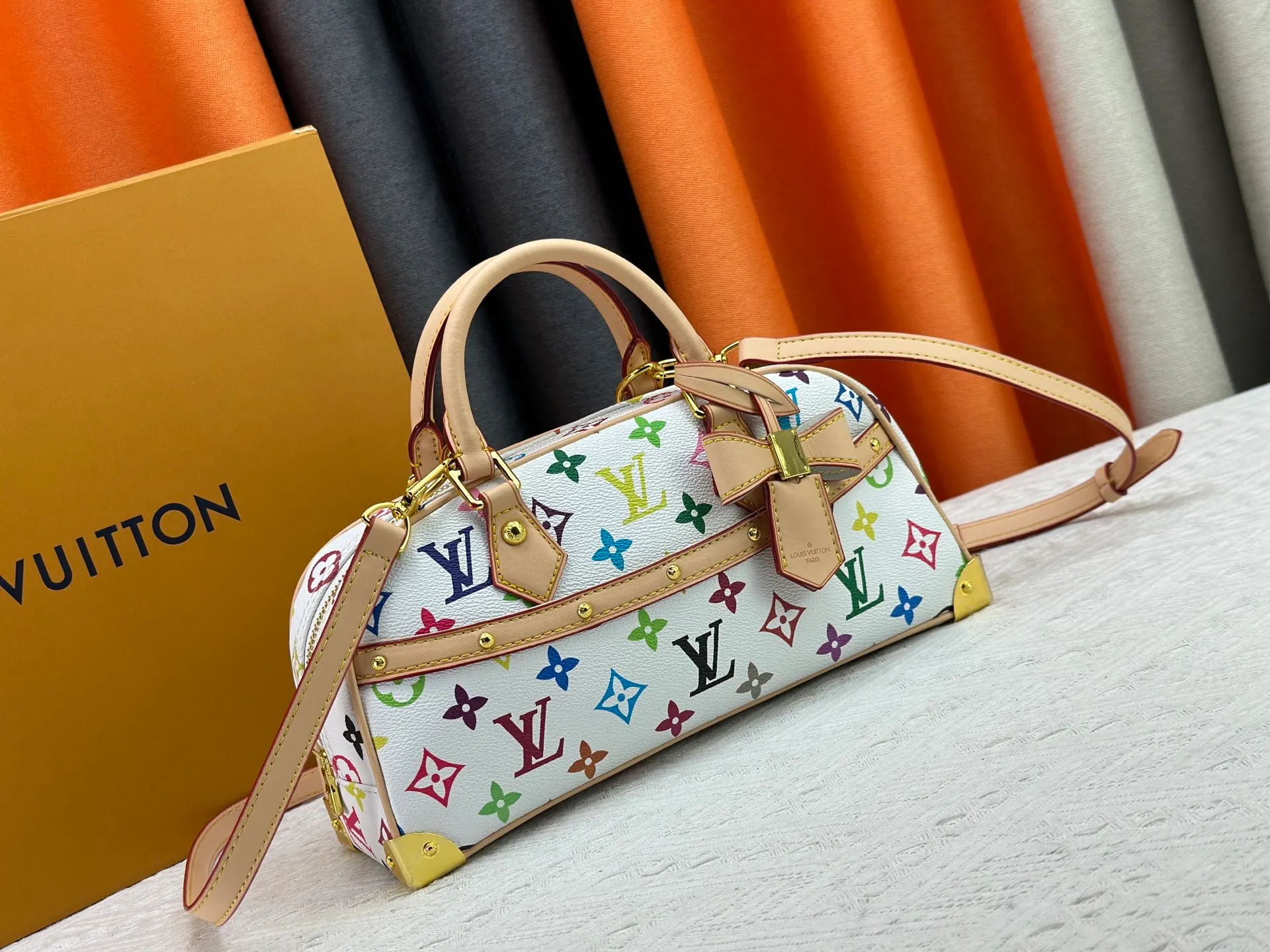 P280 Upgraded Original M13084 This Handbag East West handbag is from the Louis Vuitton x Takashi Murakami reissue series, using the artist's signature rainbow tones to trace the full-length Monogram pattern. Sleek horizontal construction lines the top handle, studded side straps, detachable and adjustable shoulder strap and LV x TM key holder, with cowhide leather details and sophisticated corners that nod to the brand's traditional luggage. Dimensions: 27.0 x 14.0 x 10.0 cm (length x height x width)