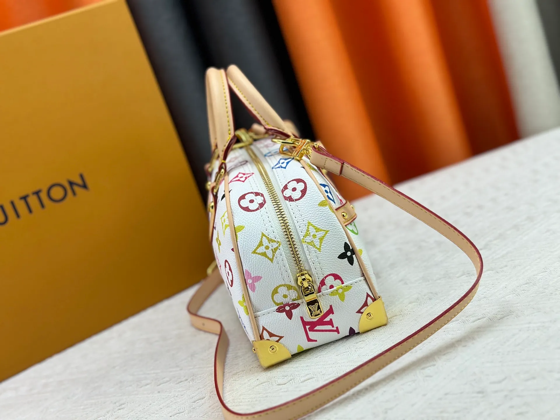 P280 Upgraded Original M13084 This Handbag East West handbag is from the Louis Vuitton x Takashi Murakami reissue series, using the artist's signature rainbow tones to trace the full-length Monogram pattern. Sleek horizontal construction lines the top handle, studded side straps, detachable and adjustable shoulder strap and LV x TM key holder, with cowhide leather details and sophisticated corners that nod to the brand's traditional luggage. Dimensions: 27.0 x 14.0 x 10.0 cm (length x height x width)