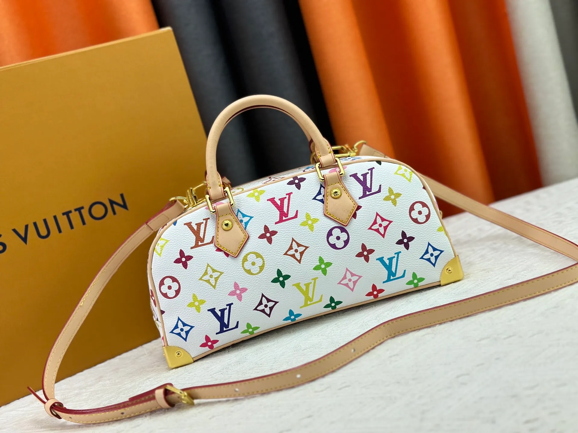 P280 Upgraded Original M13084 This Handbag East West handbag is from the Louis Vuitton x Takashi Murakami reissue series, using the artist's signature rainbow tones to trace the full-length Monogram pattern. Sleek horizontal construction lines the top handle, studded side straps, detachable and adjustable shoulder strap and LV x TM key holder, with cowhide leather details and sophisticated corners that nod to the brand's traditional luggage. Dimensions: 27.0 x 14.0 x 10.0 cm (length x height x width)