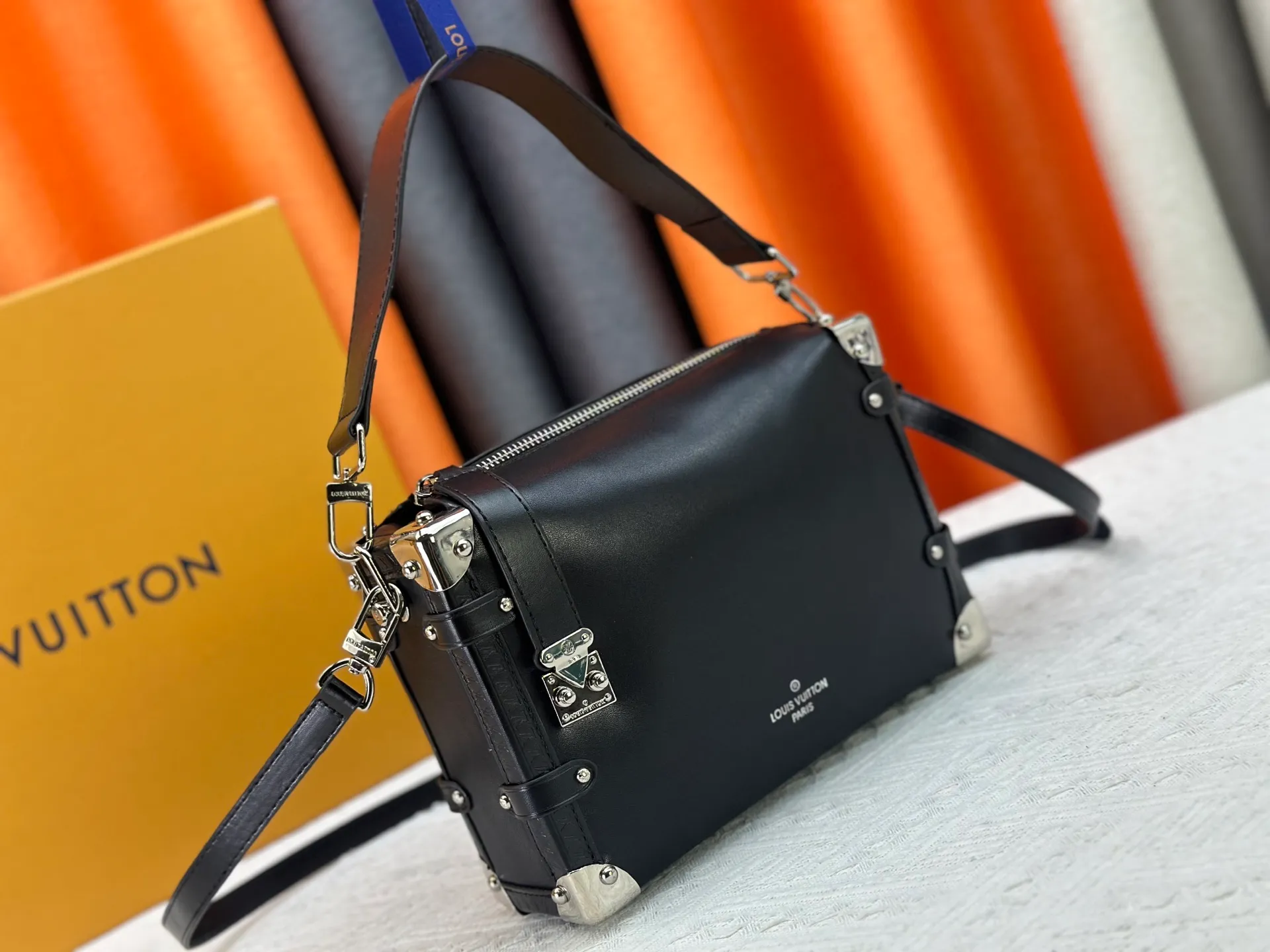 P300 M15195 M46358 This Side Trunk Vibe handbag reimagines the brand's classic Side Trunk silhouette with an avant-garde design, inspired by Louis Vuitton's traditional travel trunks. Crafted from smooth glossy Vibe textured cow leather, it features a leather-covered rivet frame and metal S-lock closure for a rock-and-roll style. Thanks to the multiple designs of the detachable chain, detachable leather handle and adjustable leather shoulder strap, it provides a variety of carrying options. Dimensions: 23.5x16x8.5cm