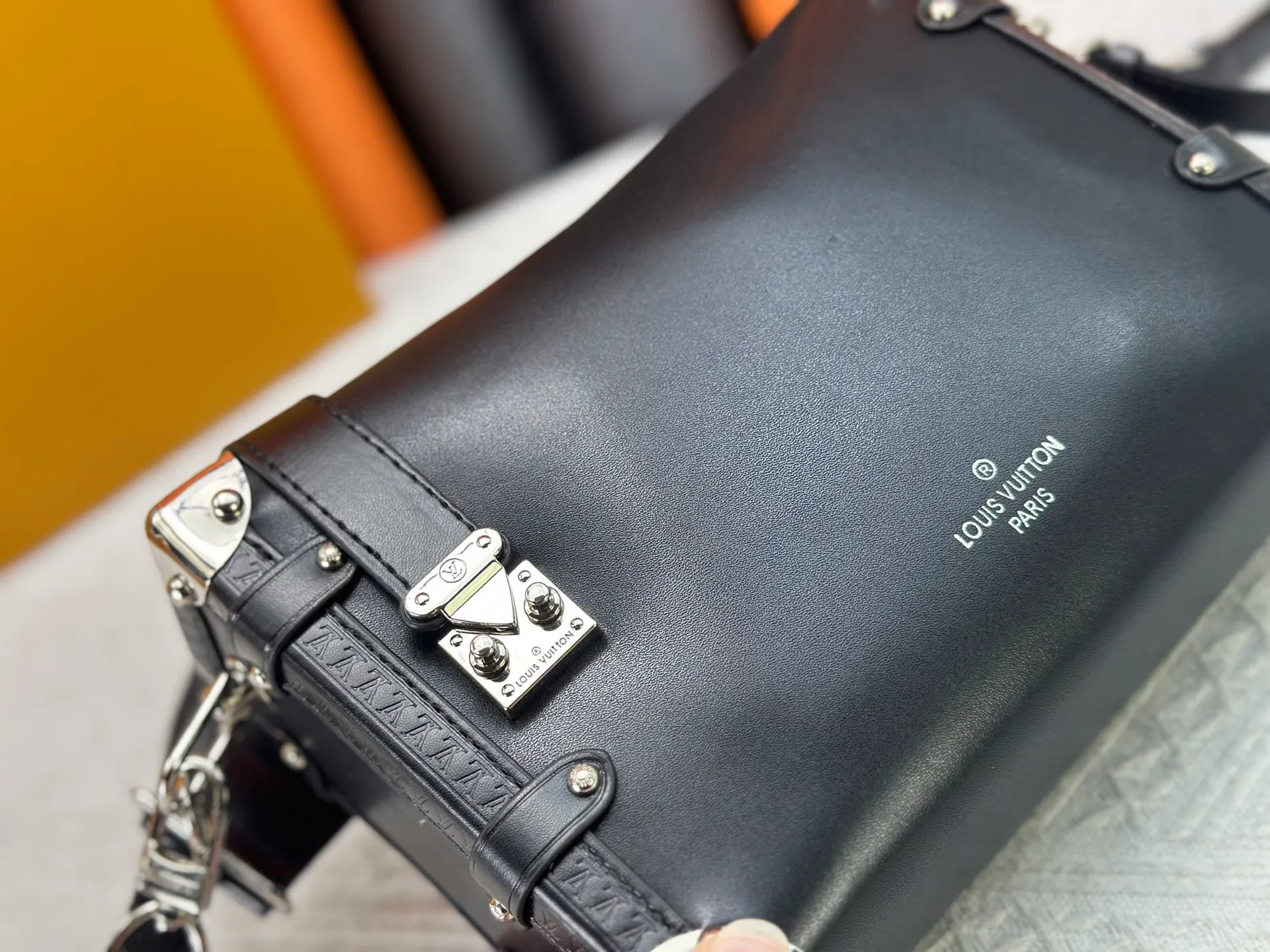 P300 M15195 M46358 This Side Trunk Vibe handbag reimagines the brand's classic Side Trunk silhouette with an avant-garde design, inspired by Louis Vuitton's traditional travel trunks. Crafted from smooth glossy Vibe textured cow leather, it features a leather-covered rivet frame and metal S-lock closure for a rock-and-roll style. Thanks to the multiple designs of the detachable chain, detachable leather handle and adjustable leather shoulder strap, it provides a variety of carrying options. Dimensions: 23.5x16x8.5cm